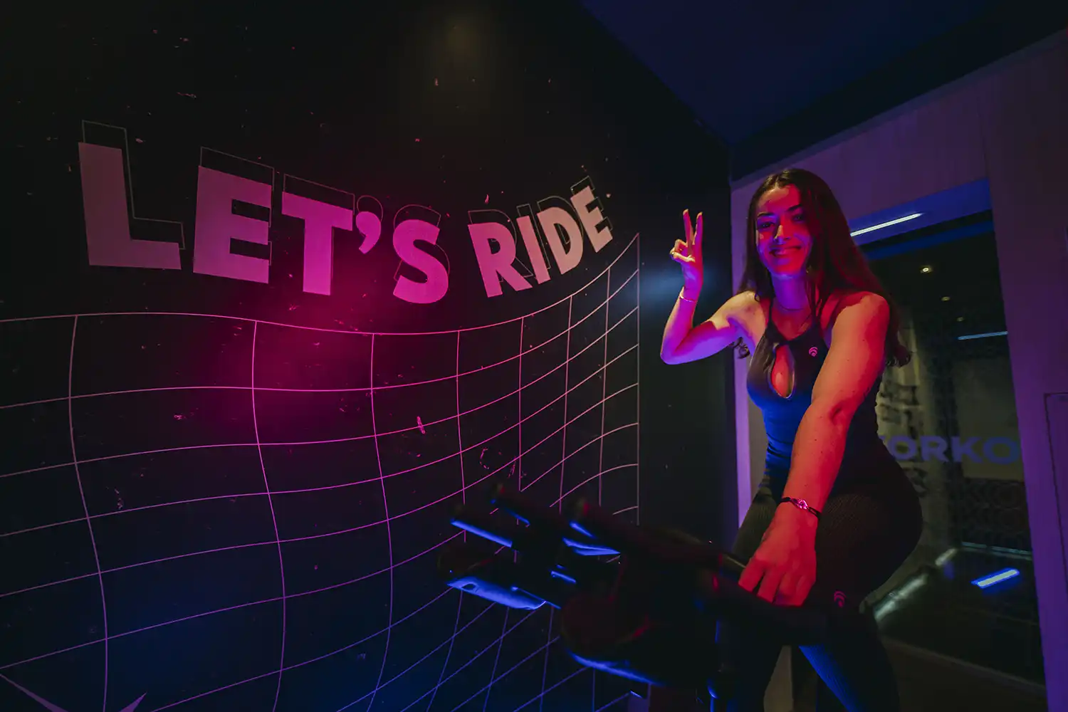 Femme souriante salle sport vélo indoor entrainement dynamique