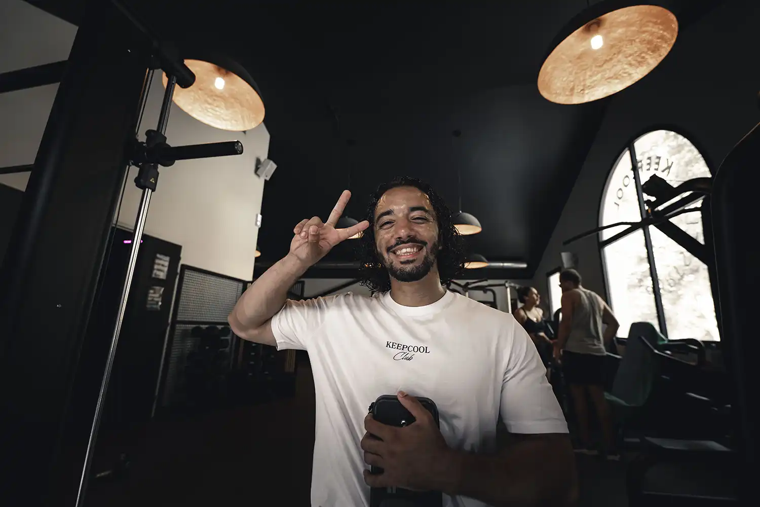 Homme souriant salle sport Keepcool pose victoire avec micro