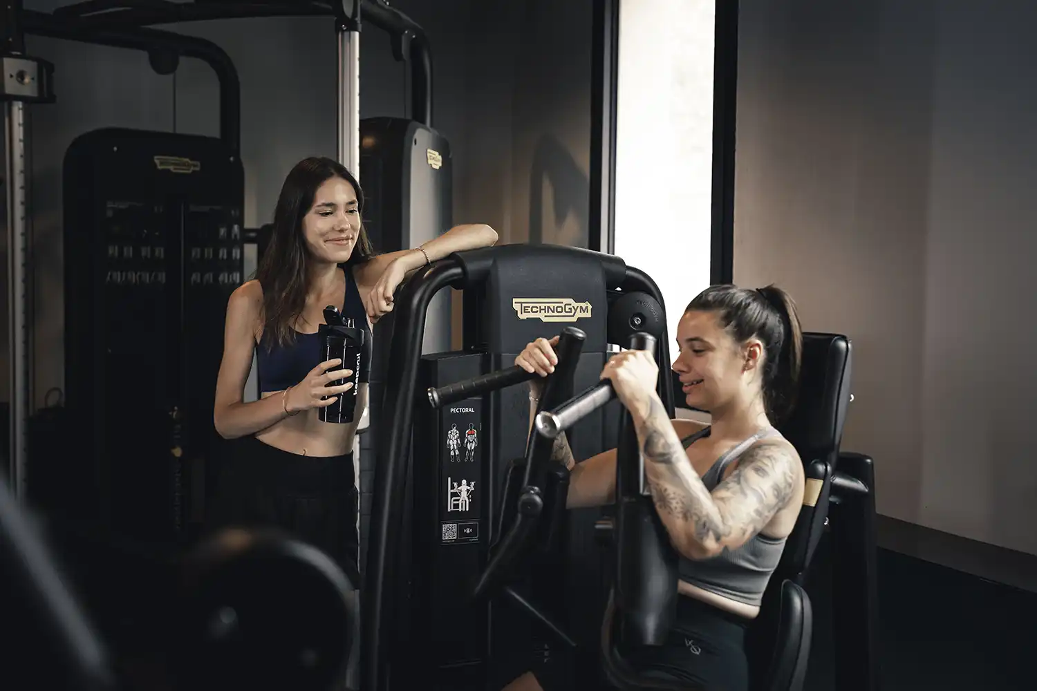 Deux personnes utilisant machine cardio en salle de sport Keepcool, entraînement en duo.