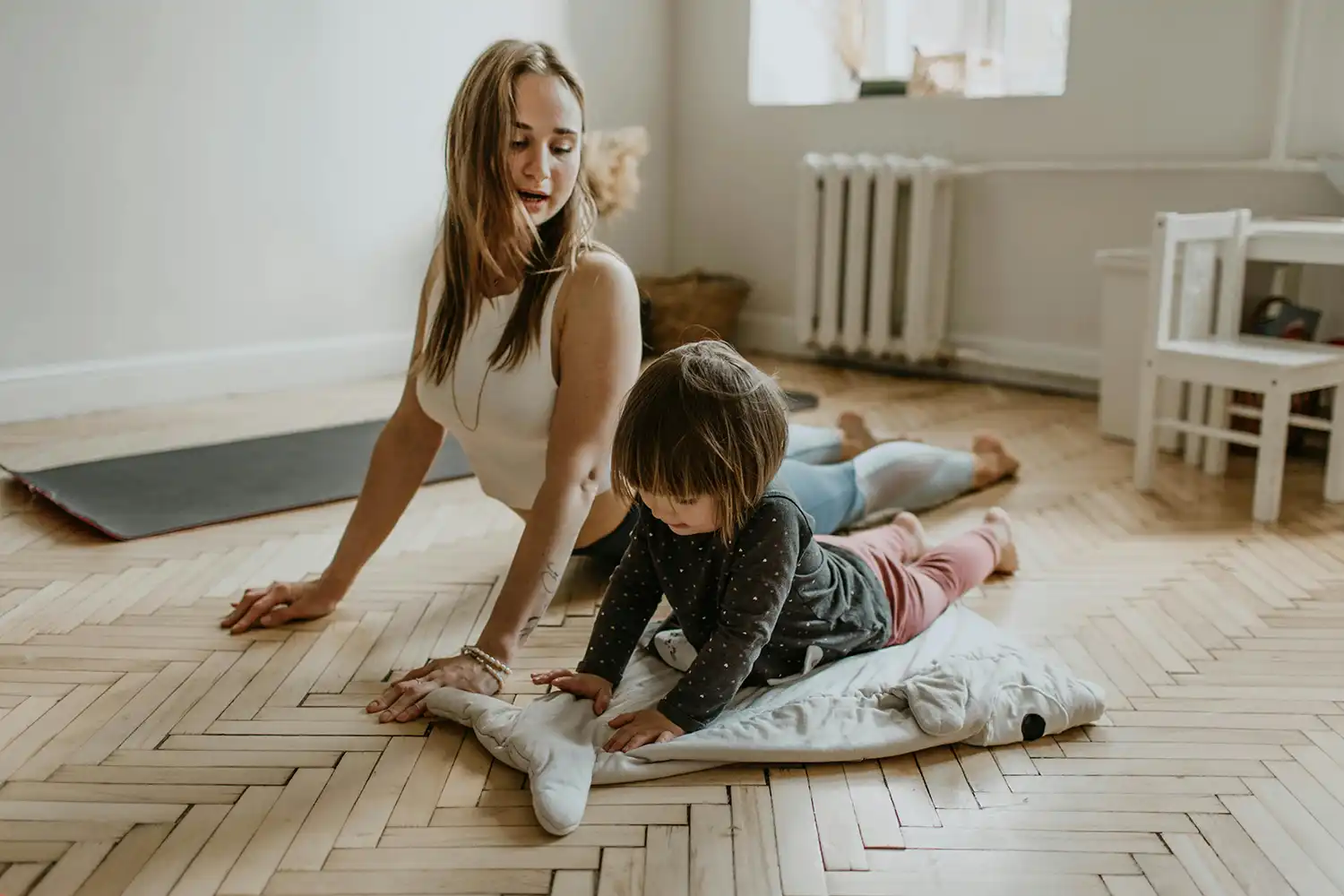Mère et enfant pratiquant yoga ensemble sur tapis dans salle de sport familiale