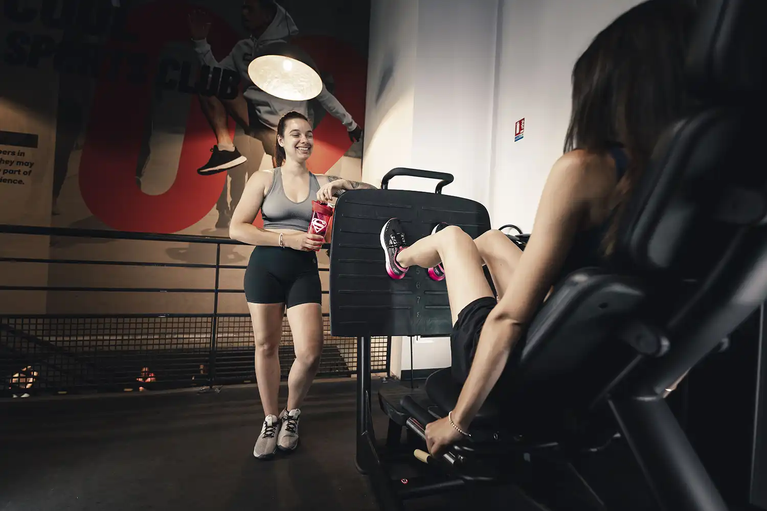 Salle de sport femme guidant exercice vélo cardio jambes lourdes