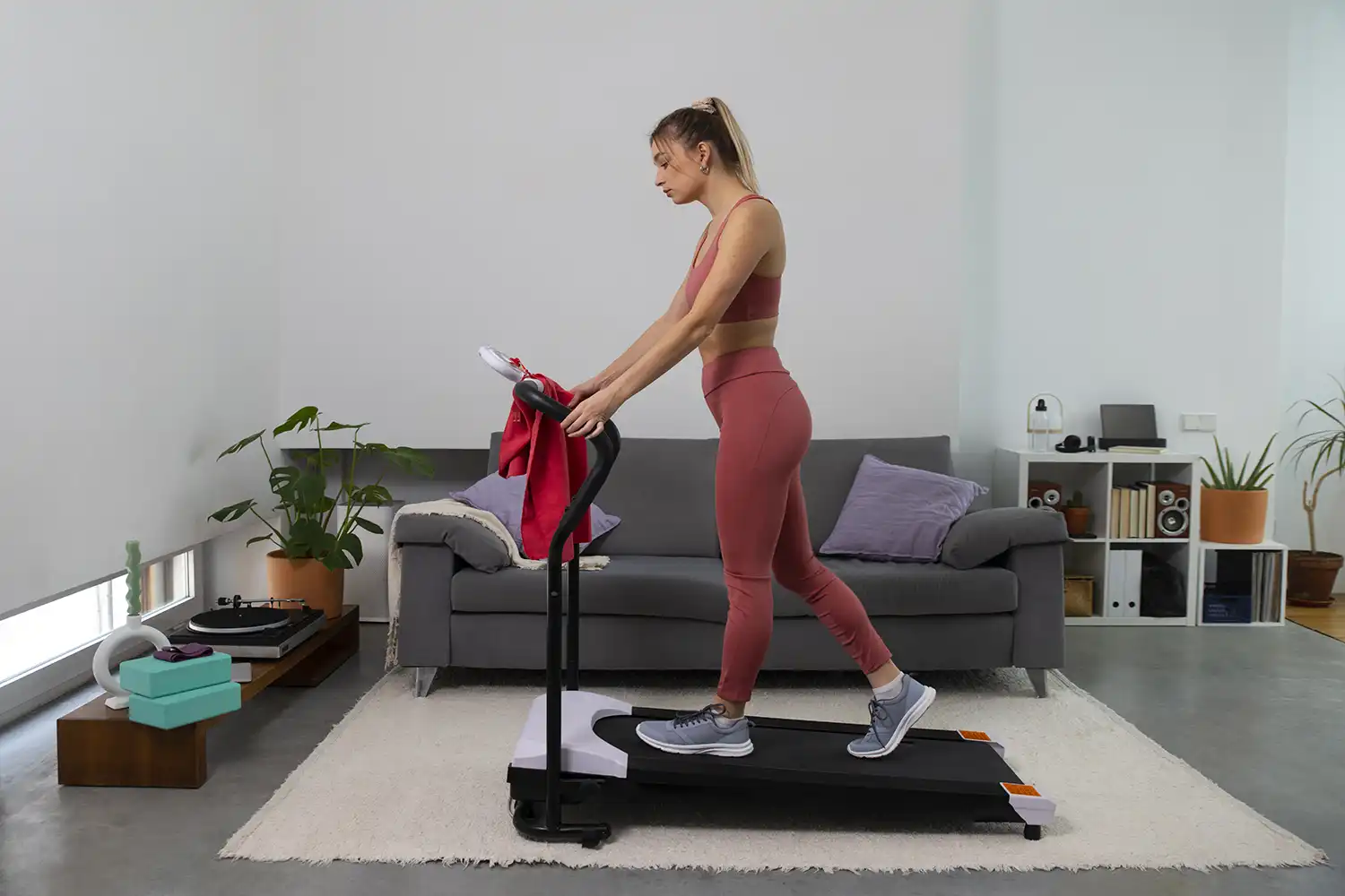 Femme utilisant tapis de course à domicile pour séance cardio fitness
