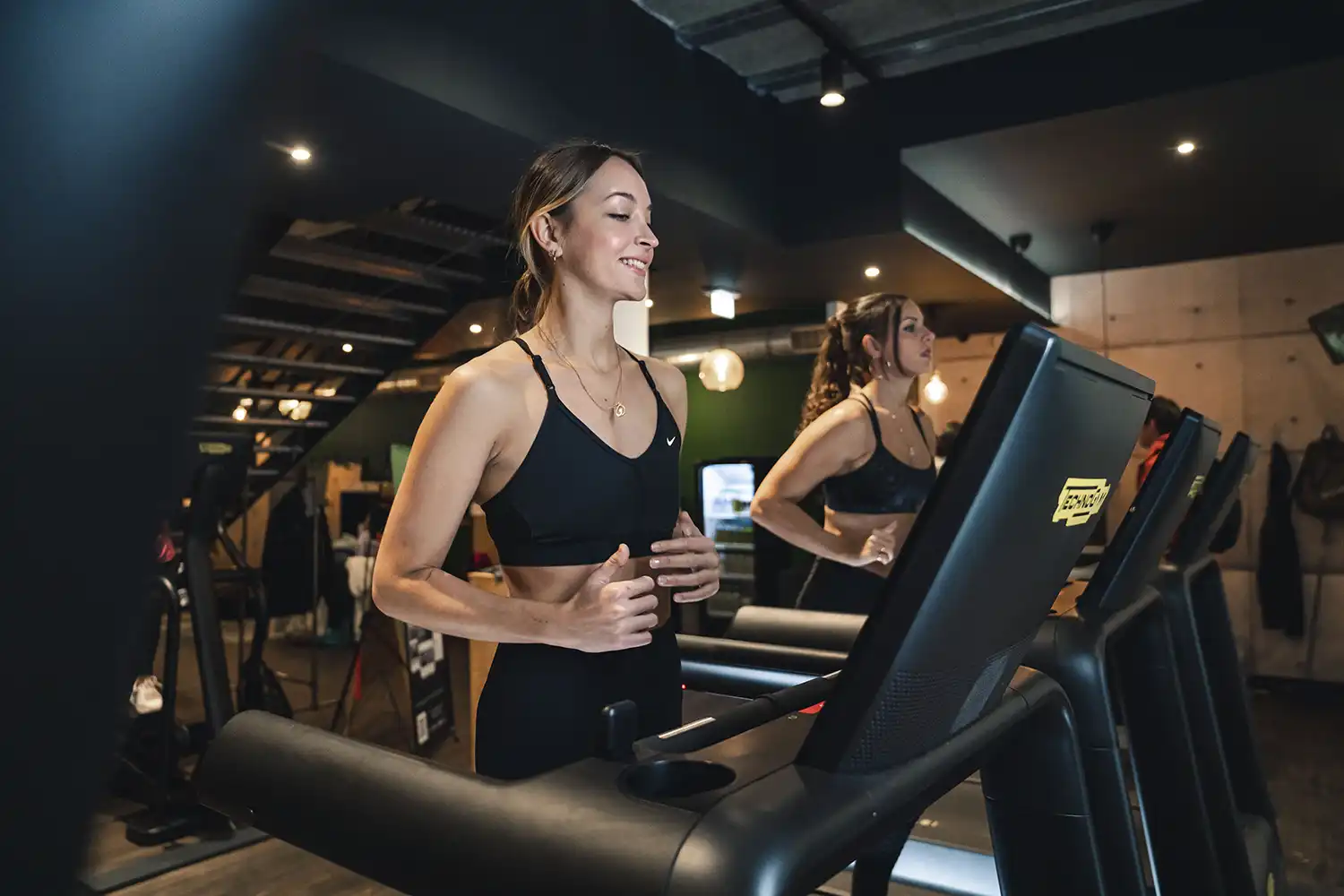 Femme souriant utilisant tapis de course en salle de sport Keepcool