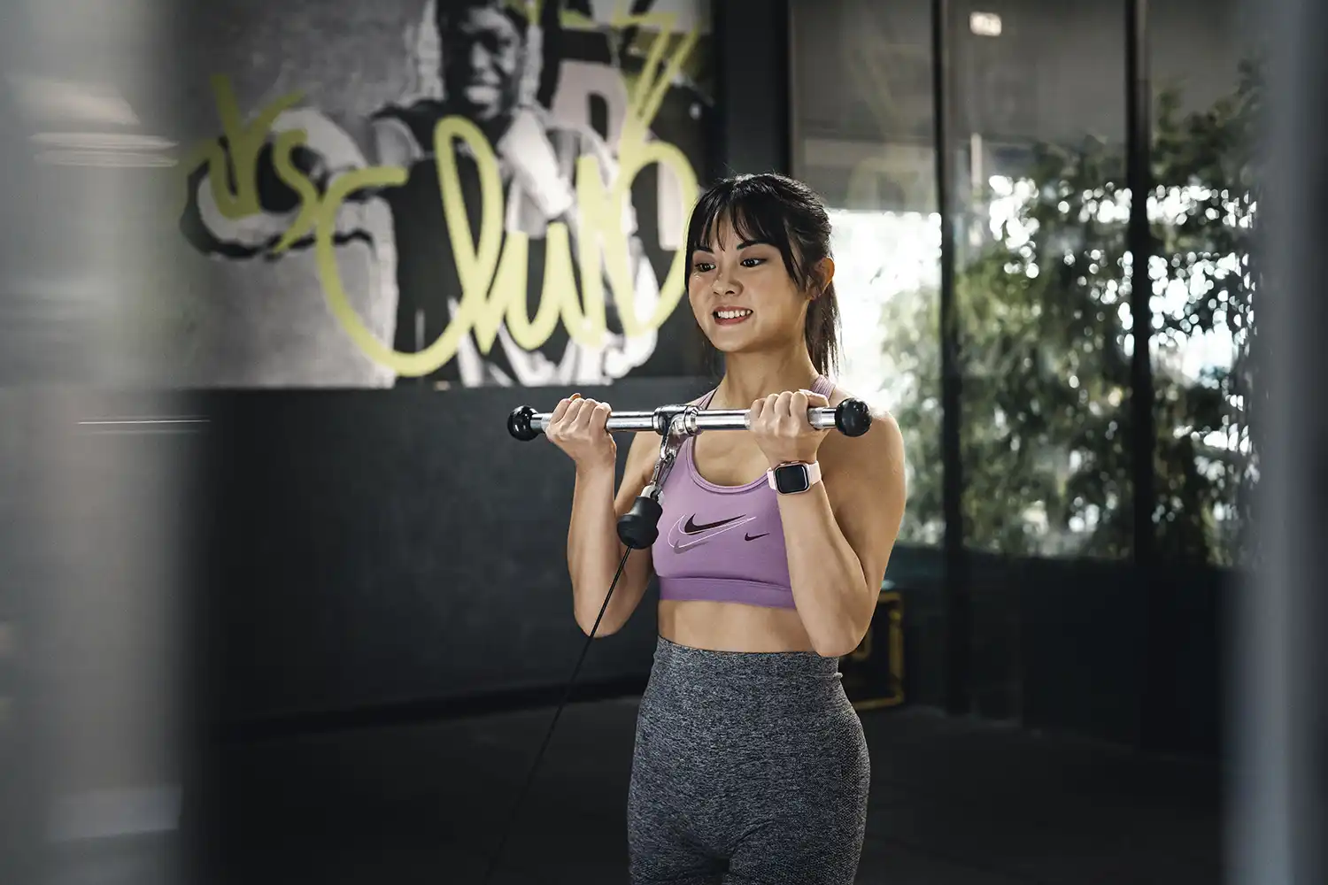 Femme en salle de sport utilisant haltères pour séance musculation