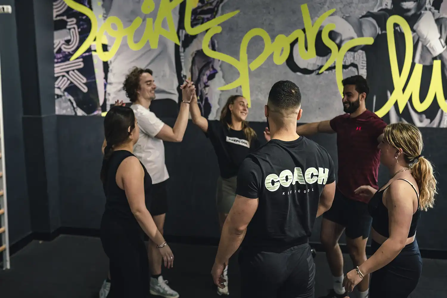 Groupes sportifs en salle faisant high-five, ambiance coaching dynamique Keepcool
