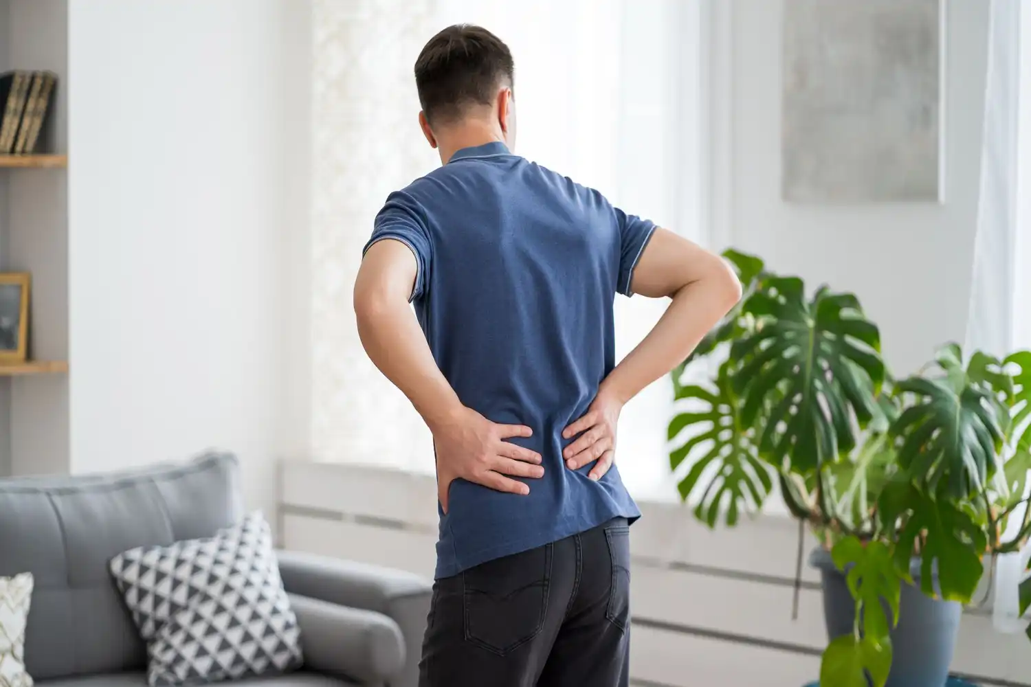 Homme avec douleurs lombaires, posture de protection pour renforcer dos et prévenir blessures, conseils santé fitness