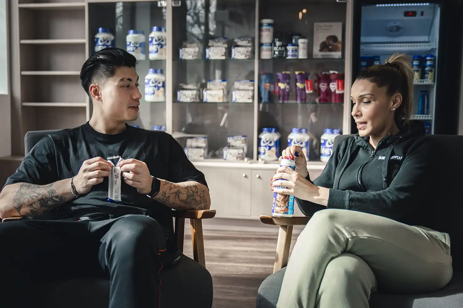 Deux athlètes discutent nutrition sportive avec boissons énergisantes dans salle Keepcool