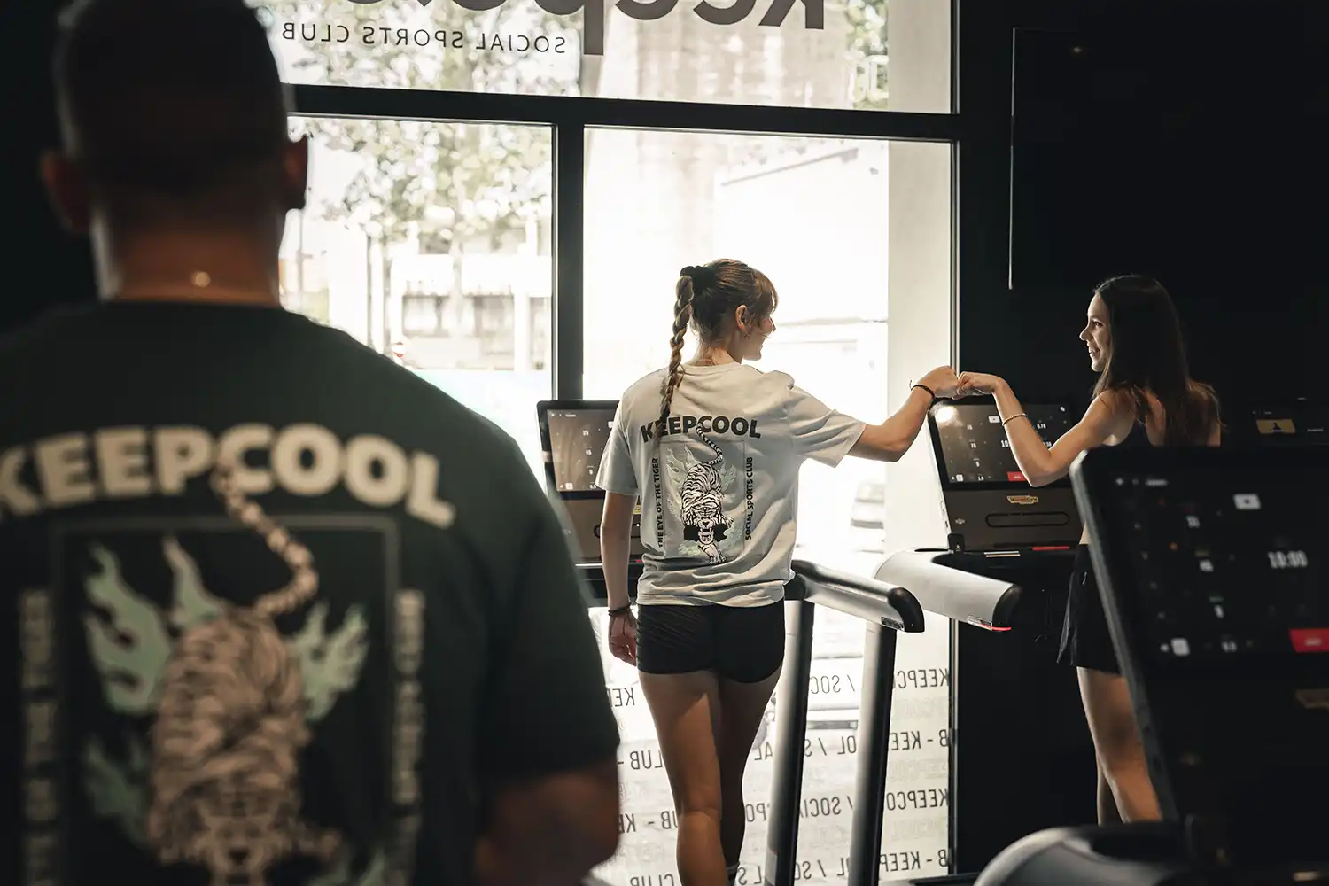 Adhérente échangeant badges à l’accueil Keepcool salle de sport moderne