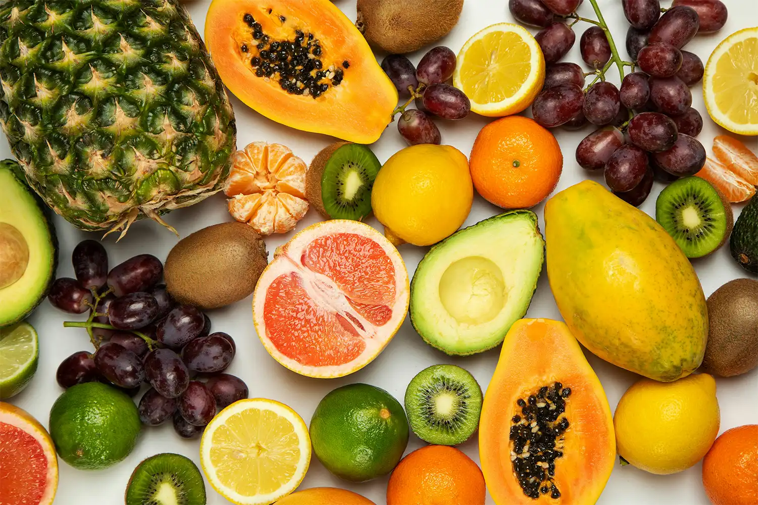 Assortiment fruits frais sains : oranges, kiwis, papayes, avocats, bananes, raisins et agrumes pour alimentation équilibrée et énergie sportive