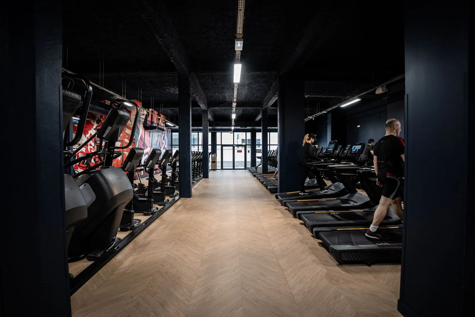 Salle de sport moderne Keepcool avec équipements cardio et musculation, espace d’entraînement intérieur éclairé.