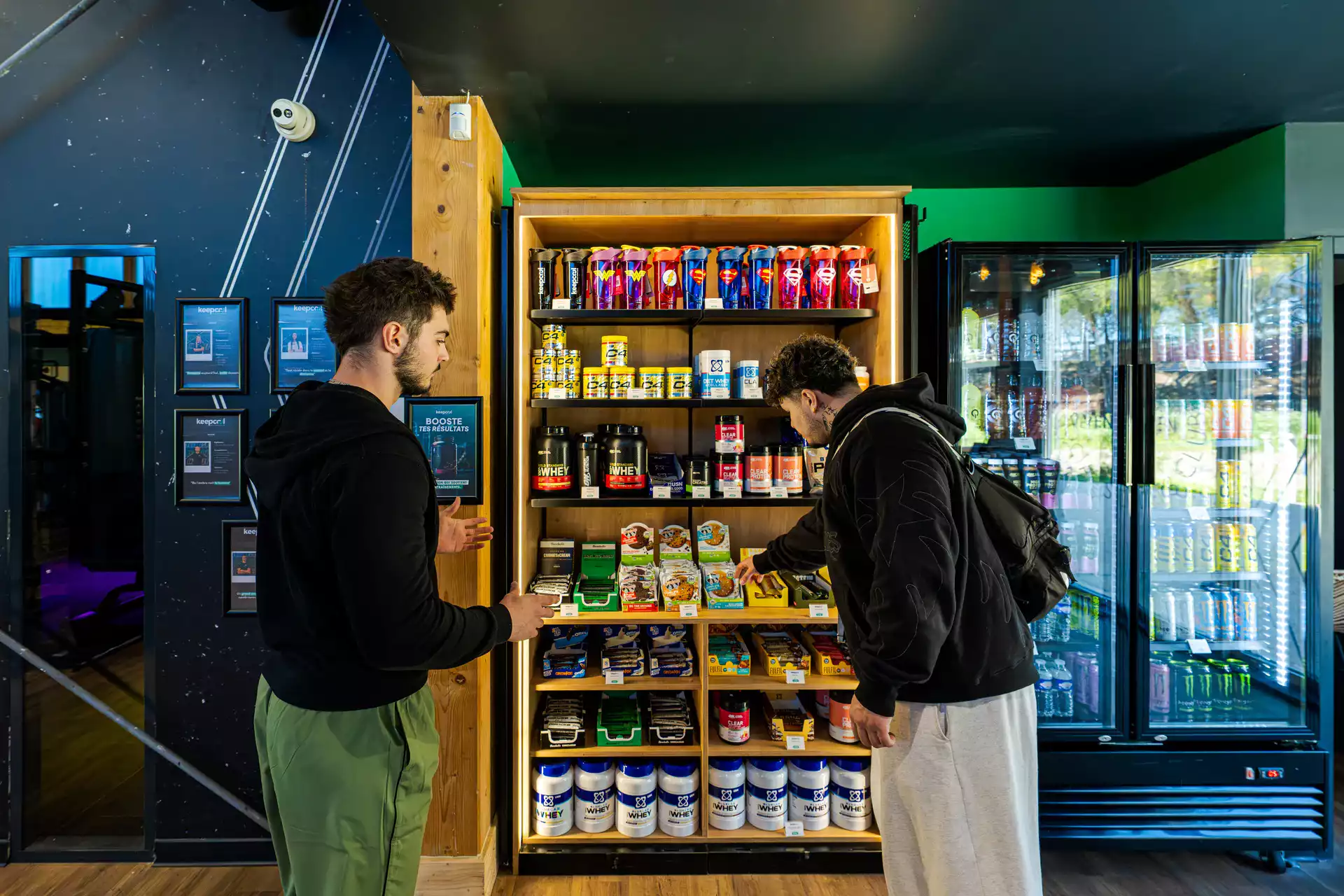 Deux personnes choisissent des boissons et compléments alimentaires dans un espace frais Keepcool.