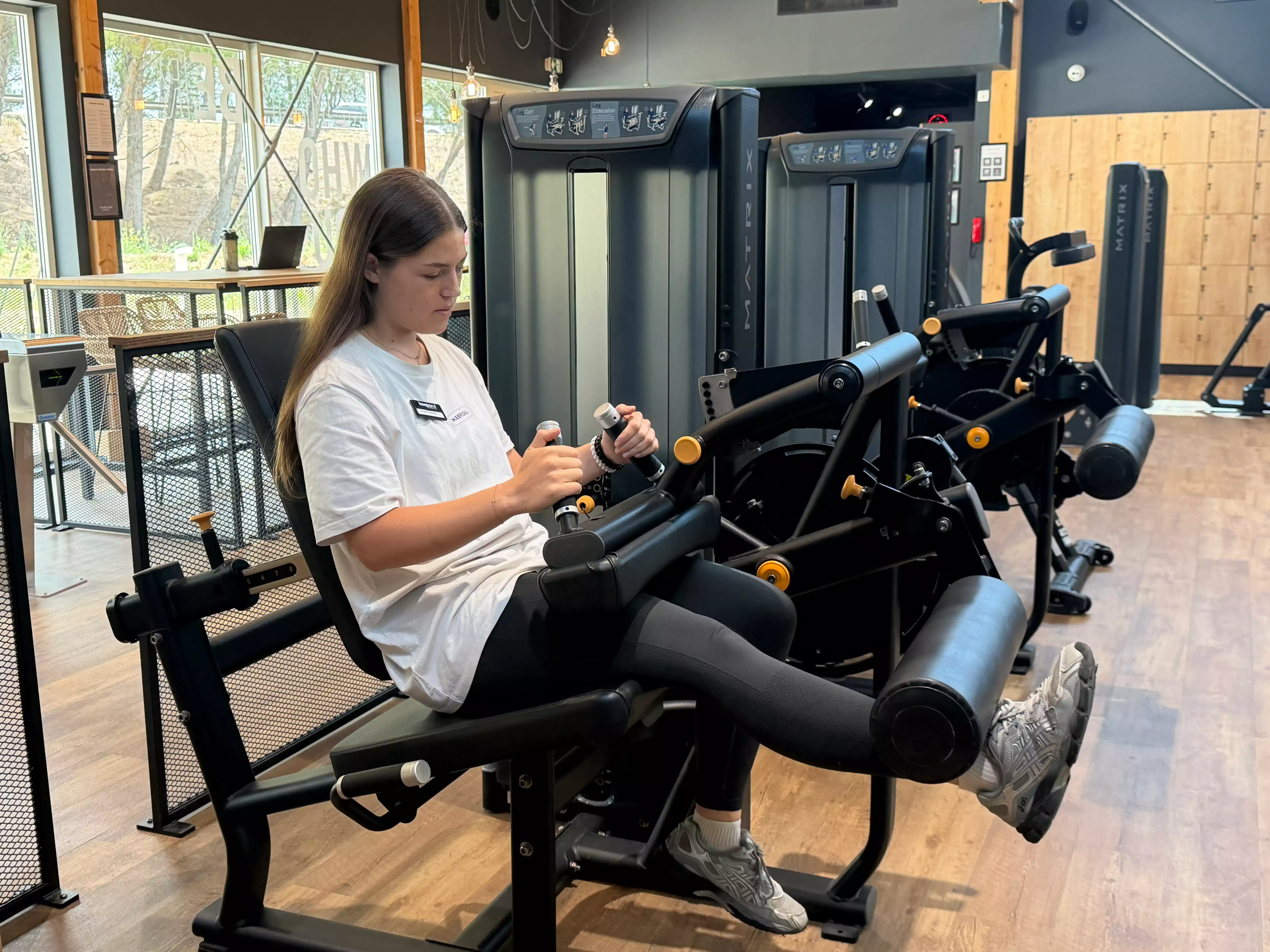 Noélie utilise une machine de musculation pour exercices de jambes en salle Keepcool.