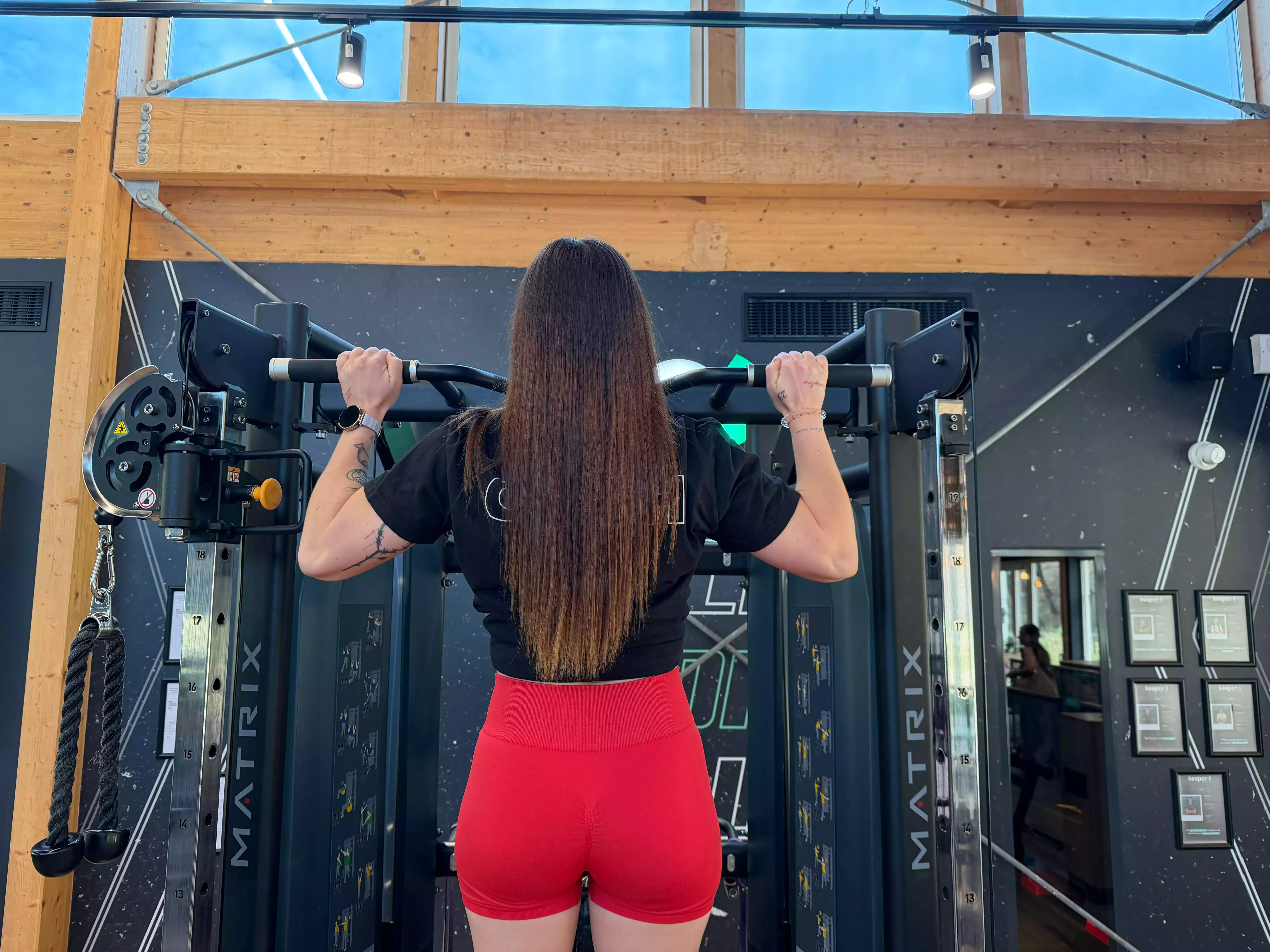Femme faisant des exercices de musculation sur machine à pectoraux en salle de sport Keepcool