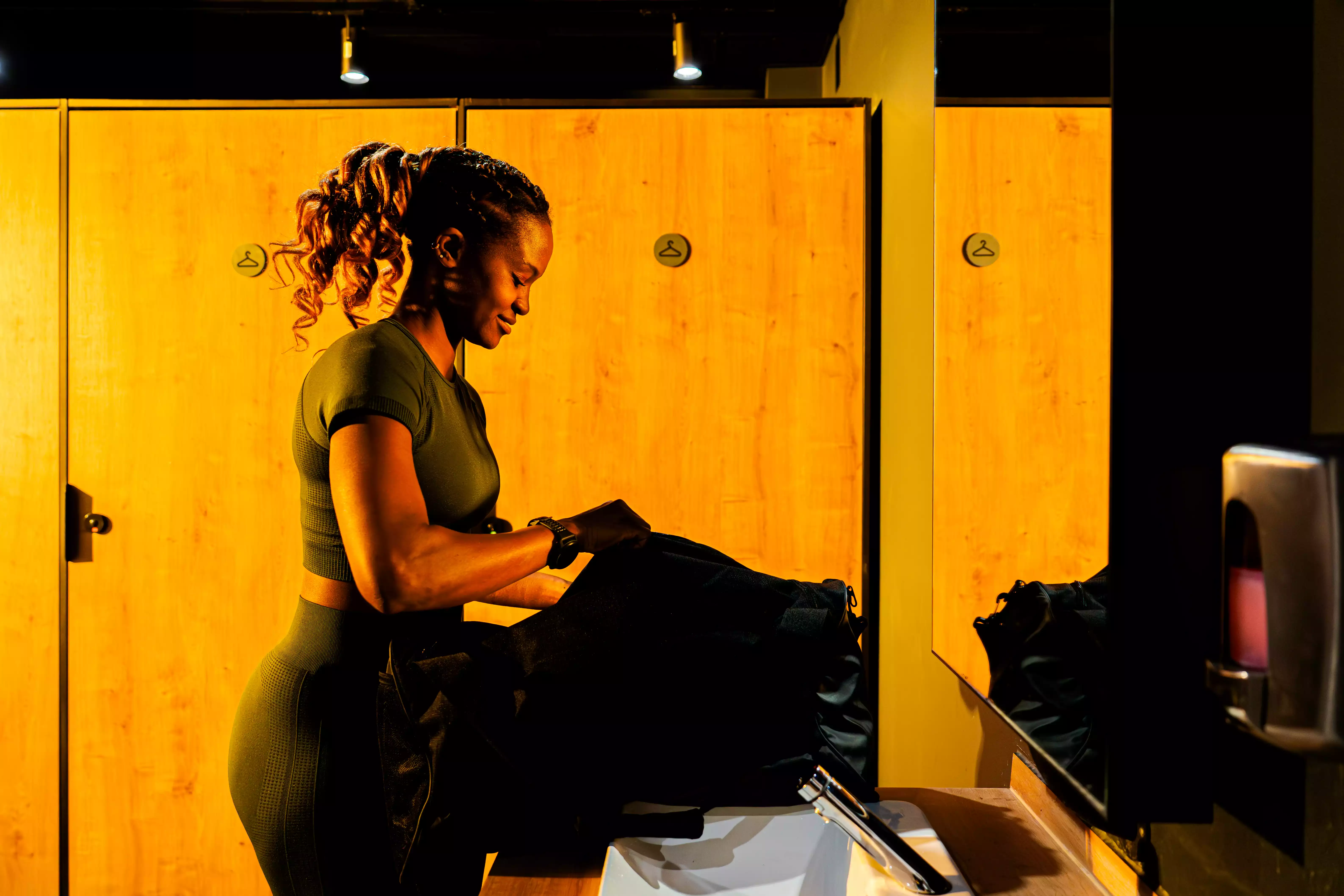 Femme en tenue sportive vérifiant chaussures près d’un vestiaire salle de sport Keepcool.