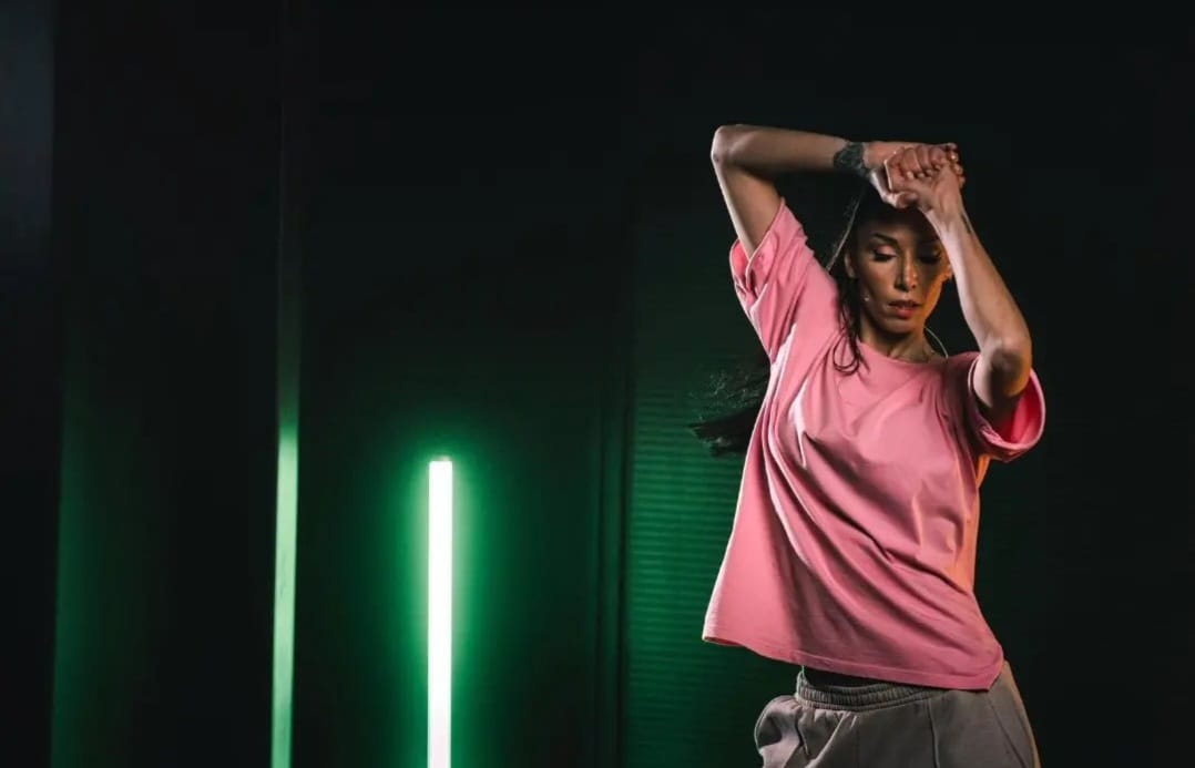 Pratique de fitness en salle avec cours collectif, femme en mouvement dynamique sous éclairage vert