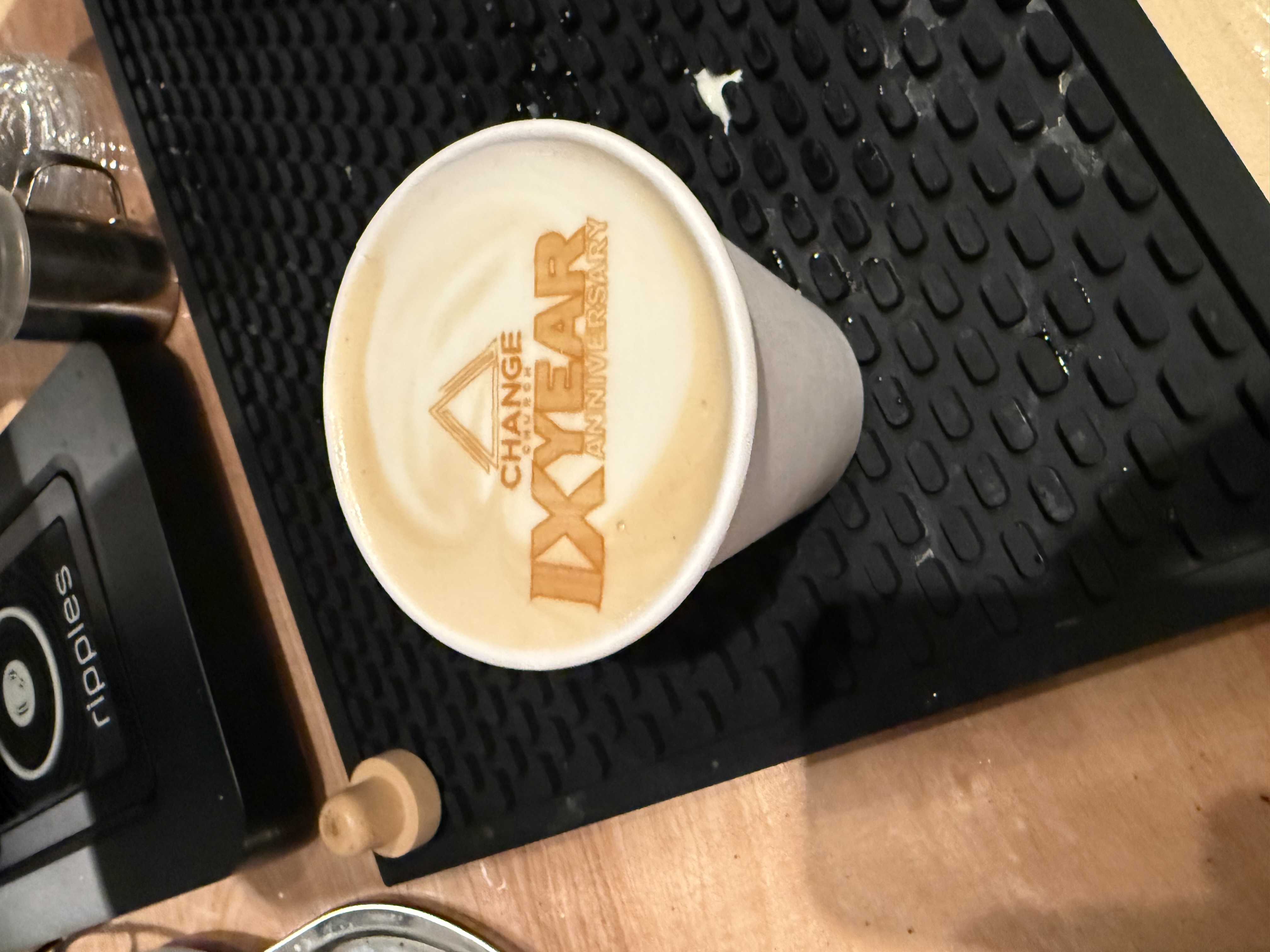 Latte with a client logo printed into the foam at an Ethos Coffee bar