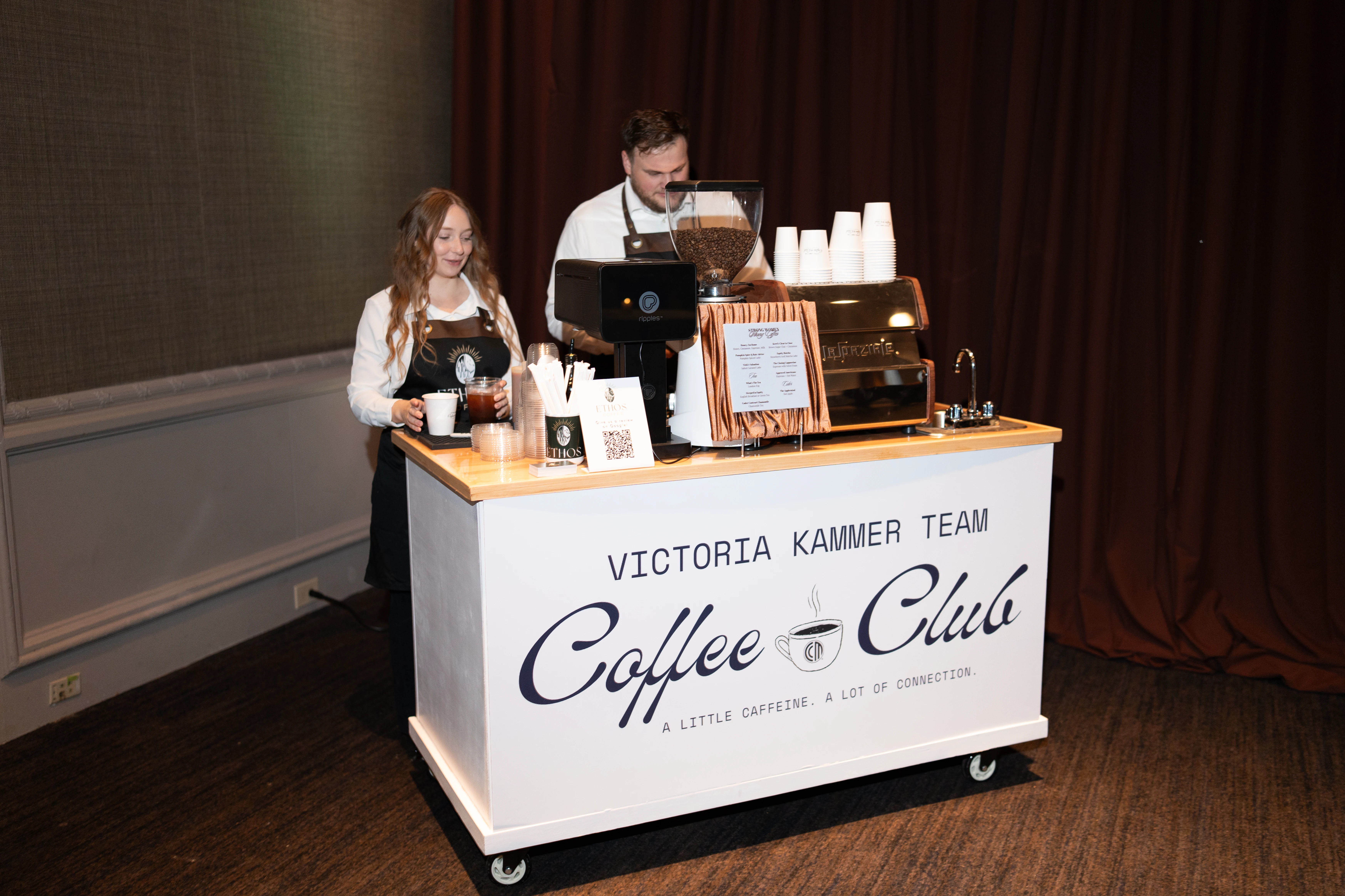 Two Ethos Coffee baristas behind the mobile espresso cart at an outdoor Philadelphia event
