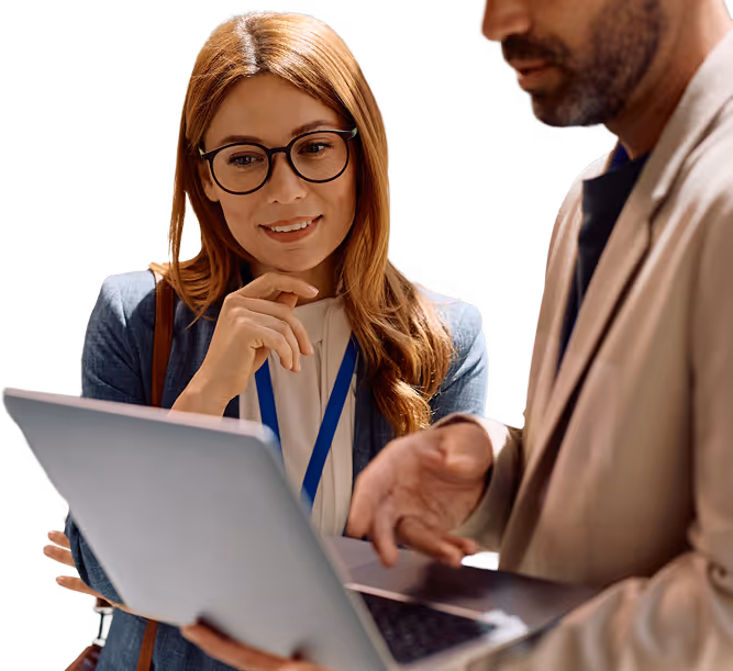 Two business professionals looking at a laptop screen, one woman with glasses and a man in a beige blazer.