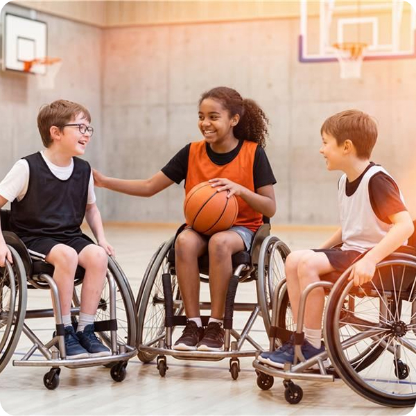Kinder spielen gemeinsam Rollstuhlbasketball in einer Sporthalle