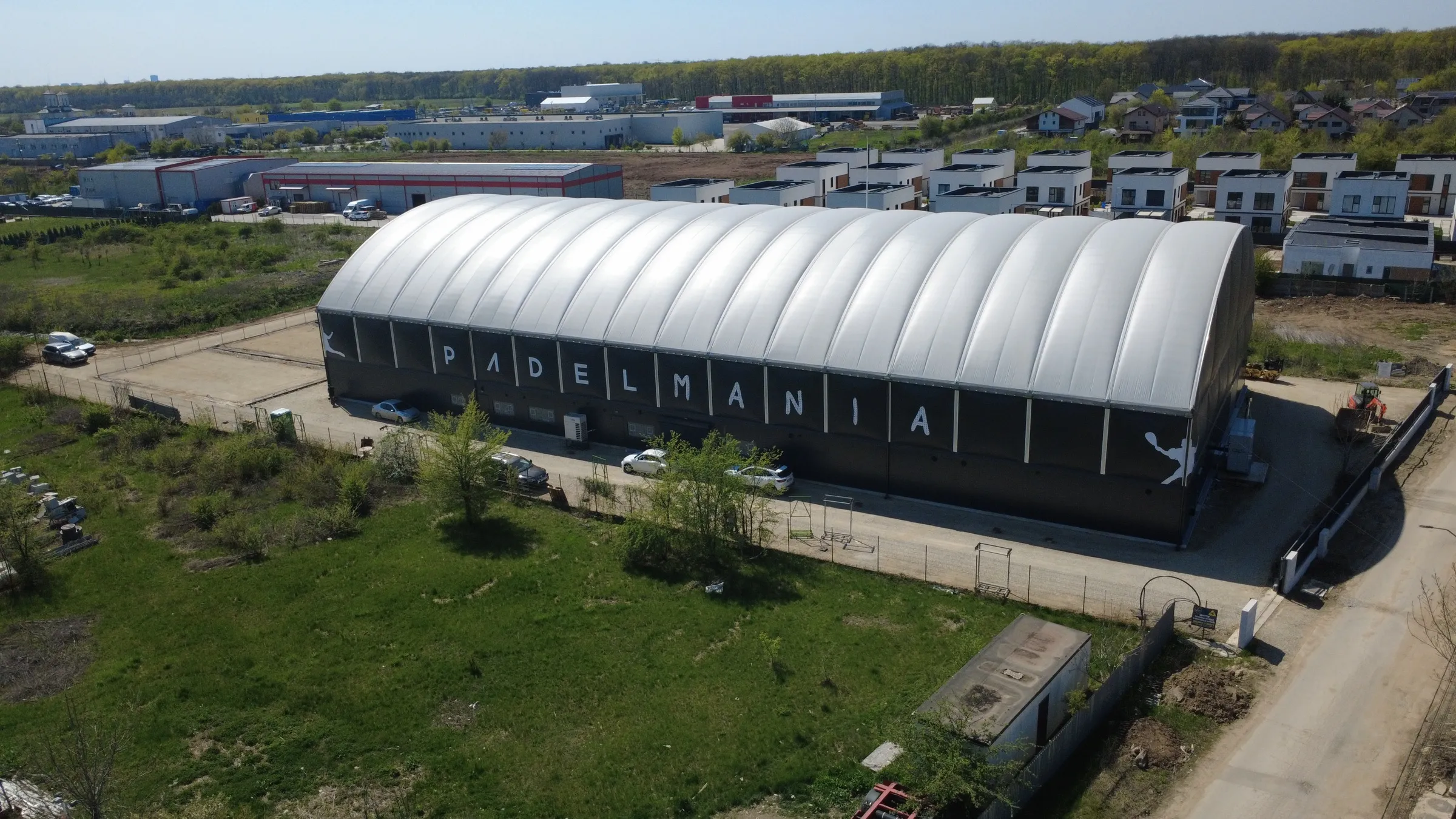 Vedere aeriană a clubului PADELMANIA Tunari, cu domul terenurilor indoor, într-o zi însorită