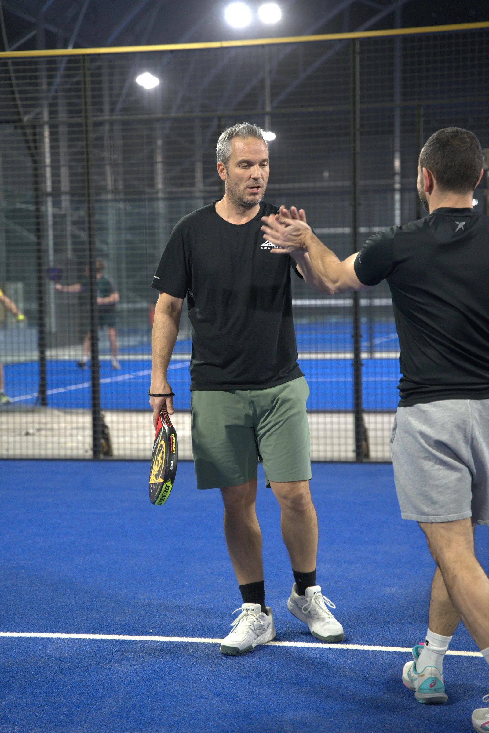 Doi jucători își dau high five pe teren după un punct reușit la PADELMANIA Tunari