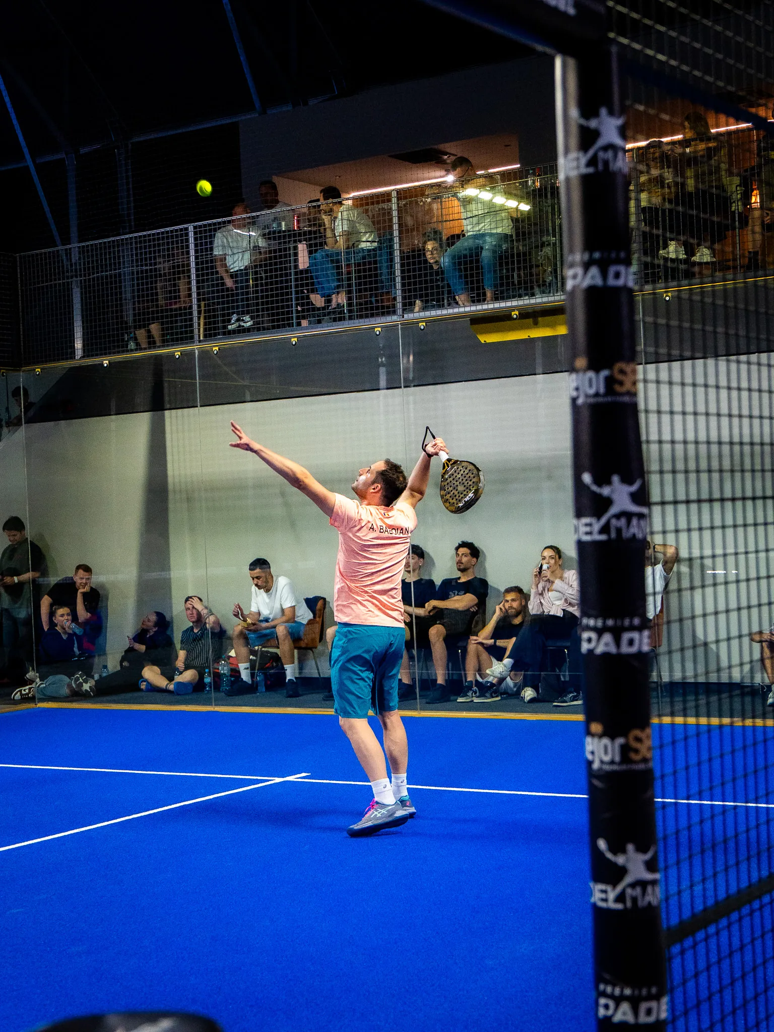 Jucător la serviciu într-un turneu, cu public pe mezanin, la PADELMANIA Tunari