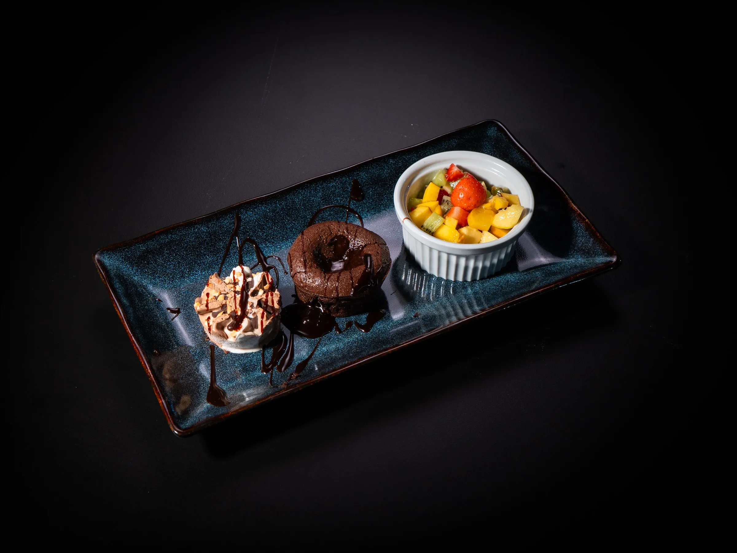 Lava cake de ciocolată, mousse și salată de fructe, desert servit la MANA Restaurant, PADELMANIA Tunari