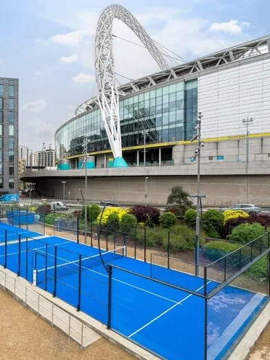 Teren de padel Panoramic RC10 cu gazon albastru, în aer liber, lângă un stadion