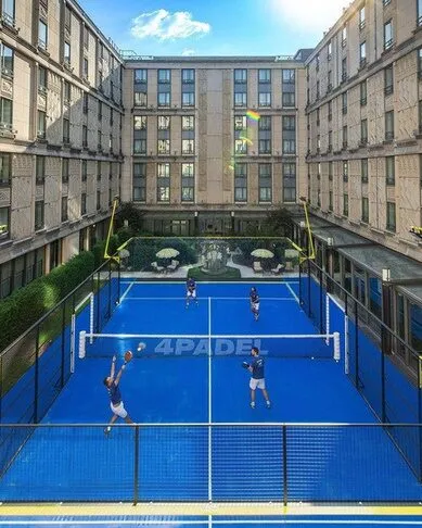 Teren de padel albastru 4Padel în curtea interioară a unei clădiri din Paris, cu jucători pe teren