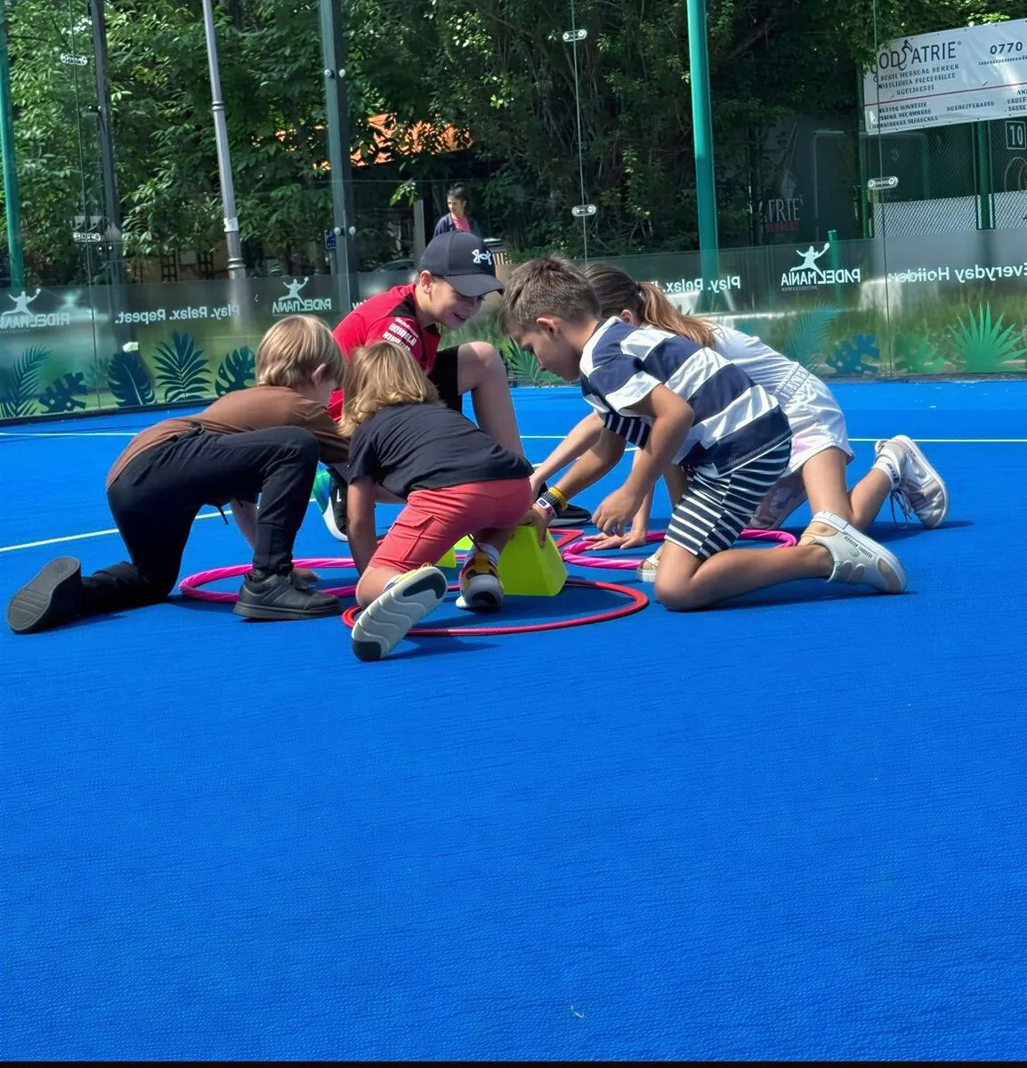 Copii la un joc de echipă pe terenul de padel, la tabăra PADELMANIA Kids Camp