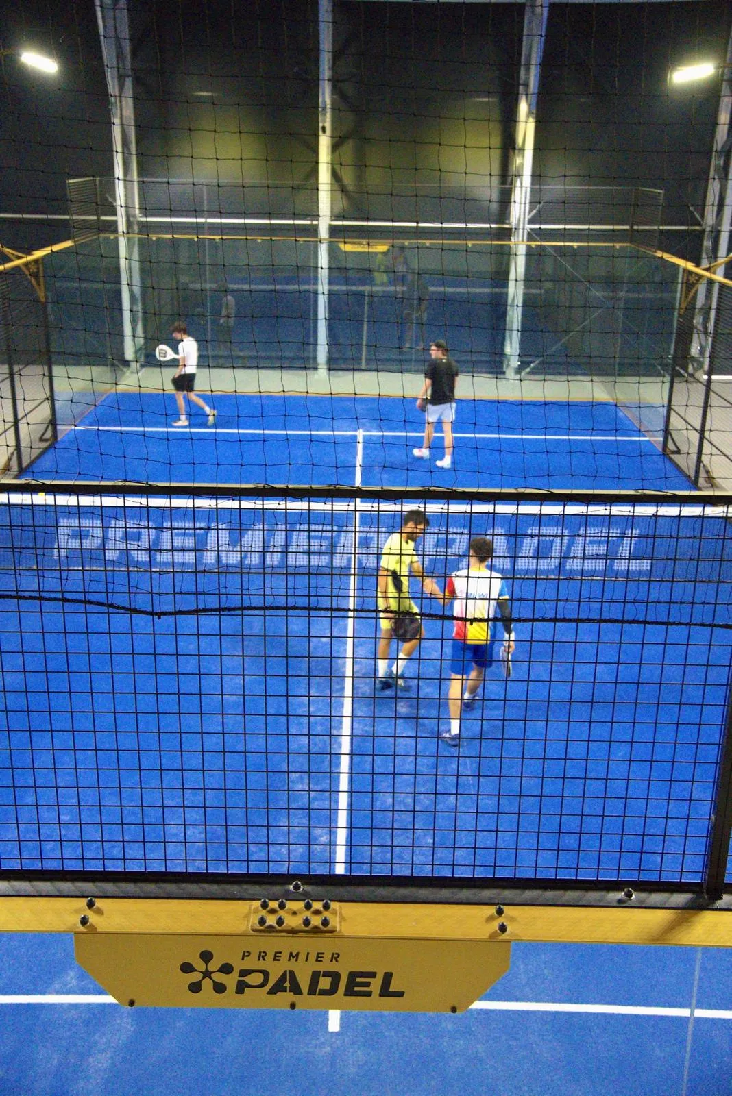 Vedere peste fileu spre un teren Premier Padel din sala acoperită PADELMANIA Tunari