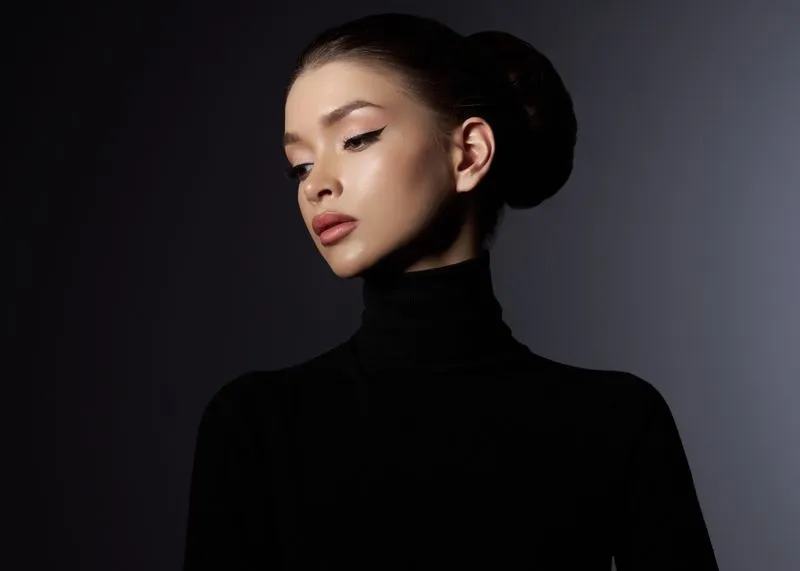 A woman wearing a black turtle neck sweater.