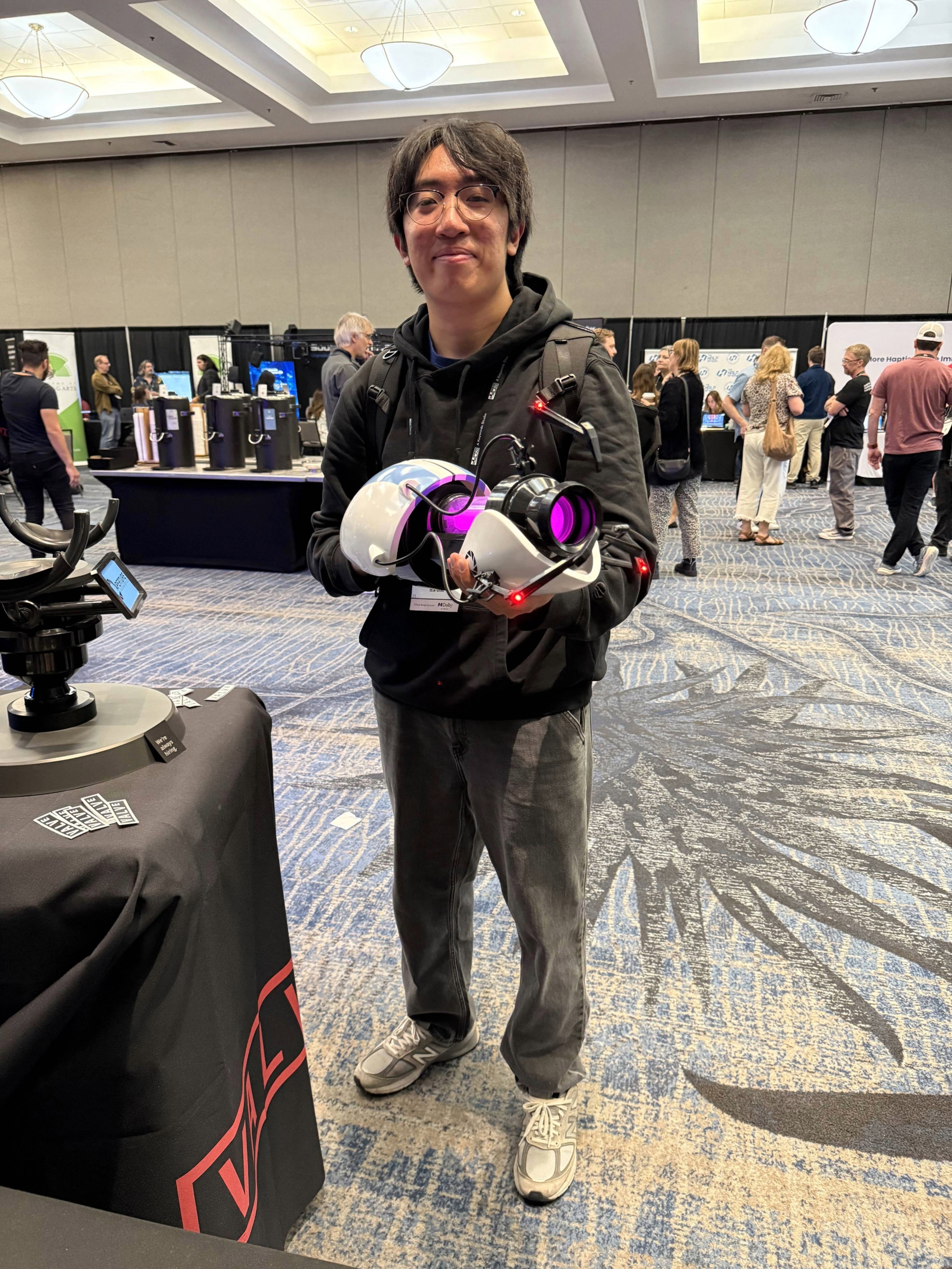 A man with glasses posing with a prop from the video game Portal at a game audio convention