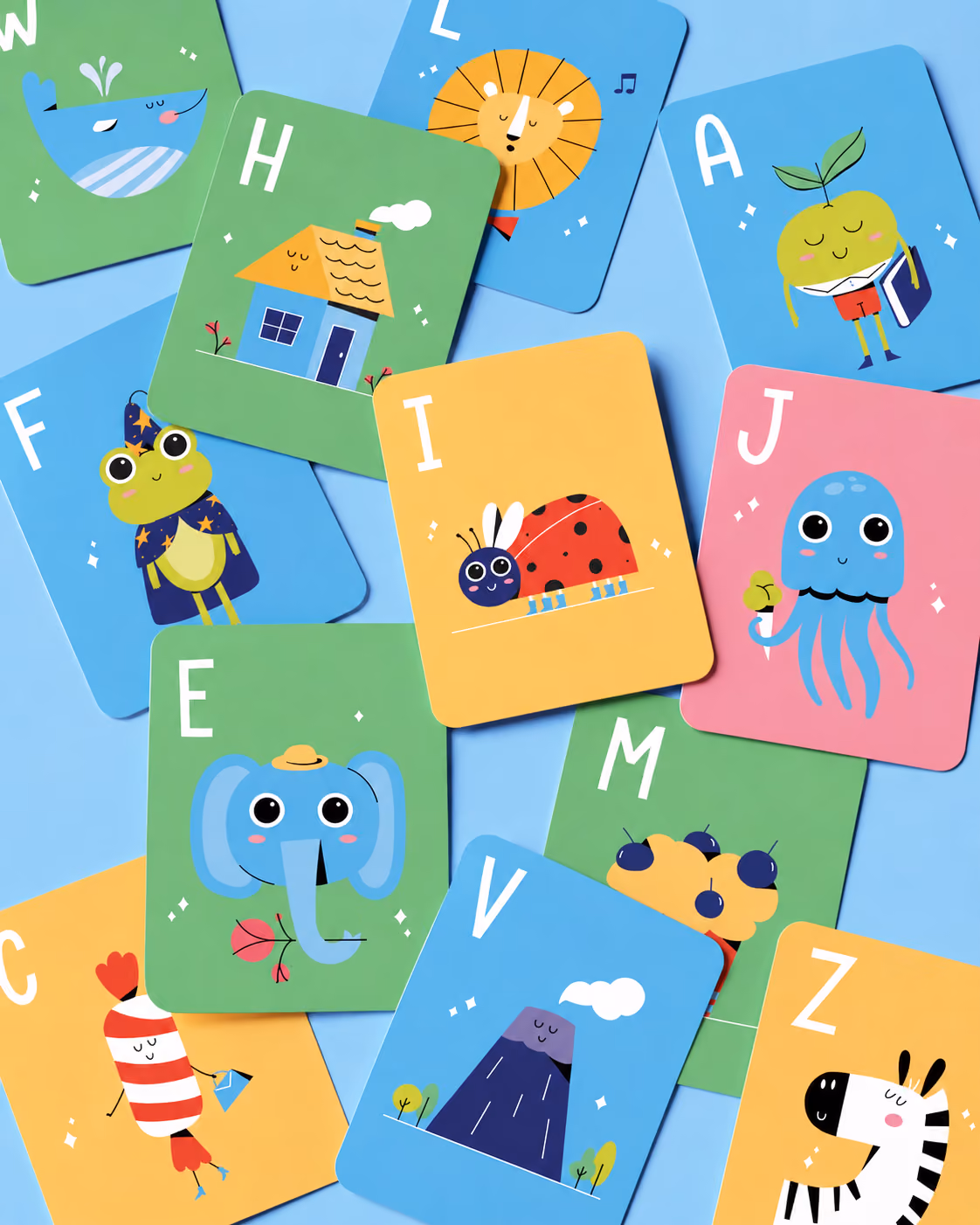 Colorful alphabet cards with cute animal and object illustrations scattered on a blue surface.