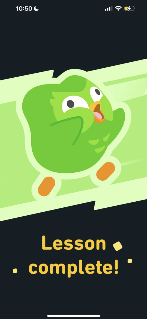 Green Duolingo owl mascot joyfully celebrating with text 'Lesson complete!'