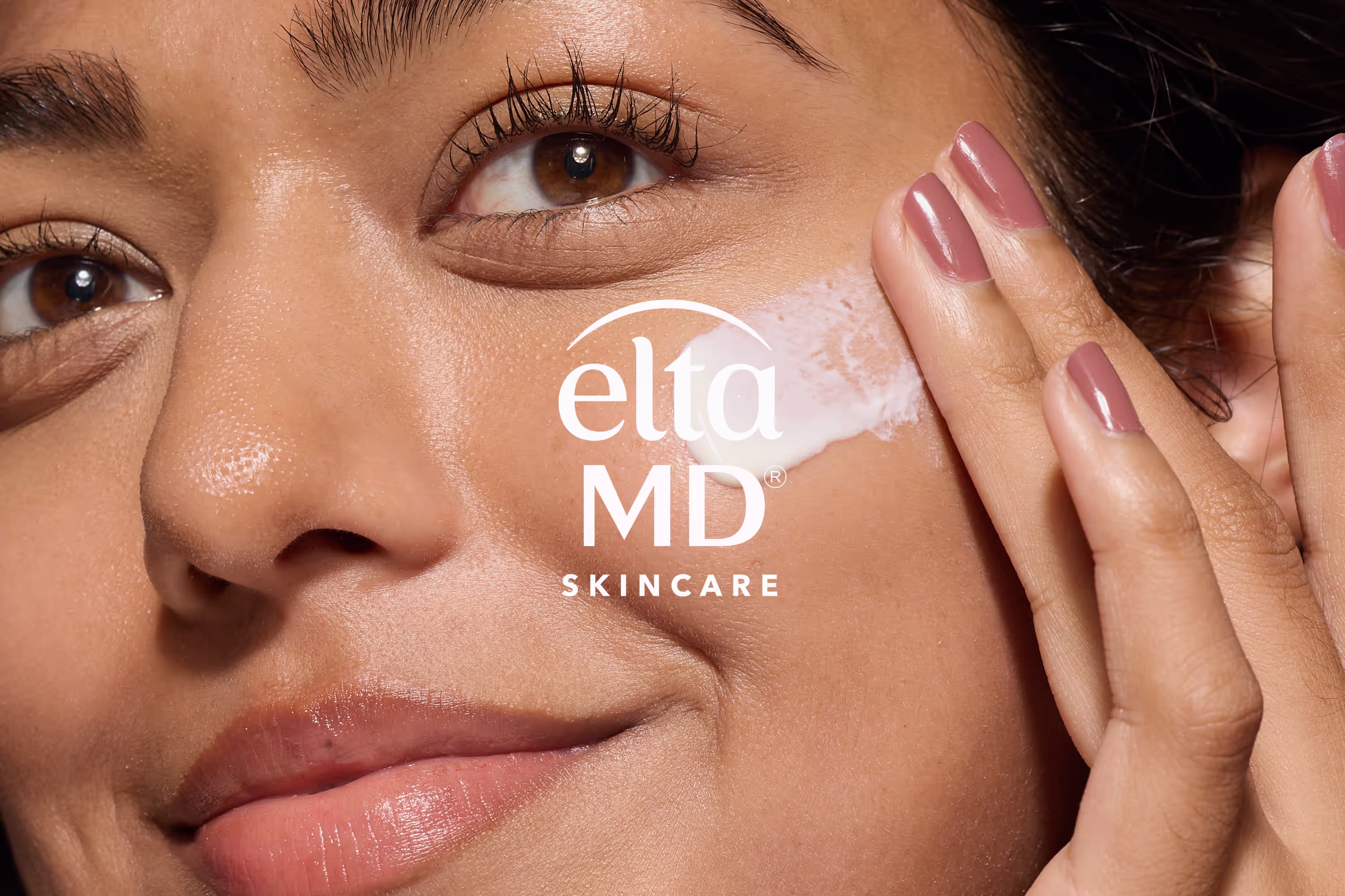Woman applying EltaMD skincare cream to her cheek, with EltaMD Skincare logo