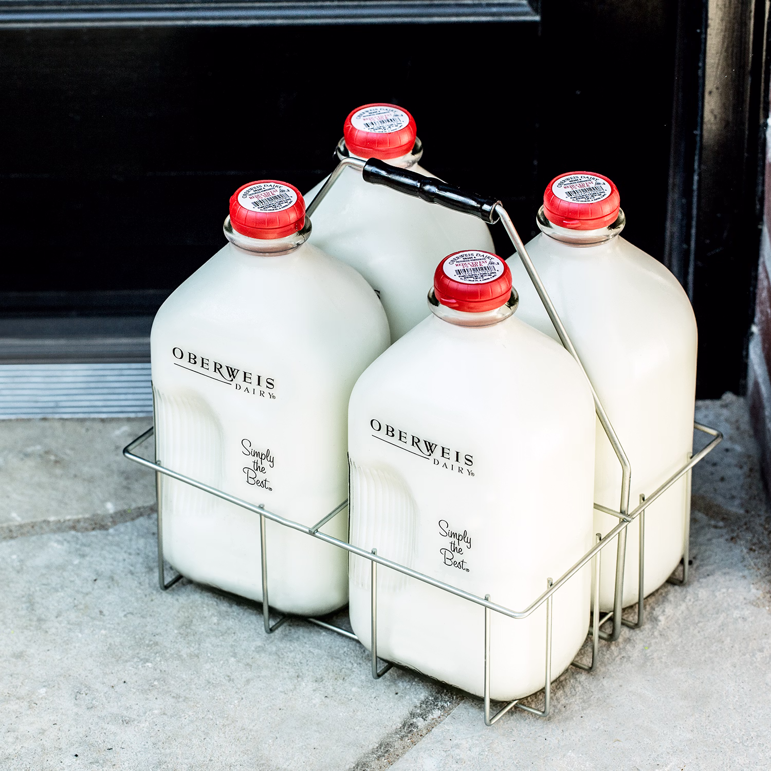 Classic Oberweis Dairy glass milk jugs in a metal carrier