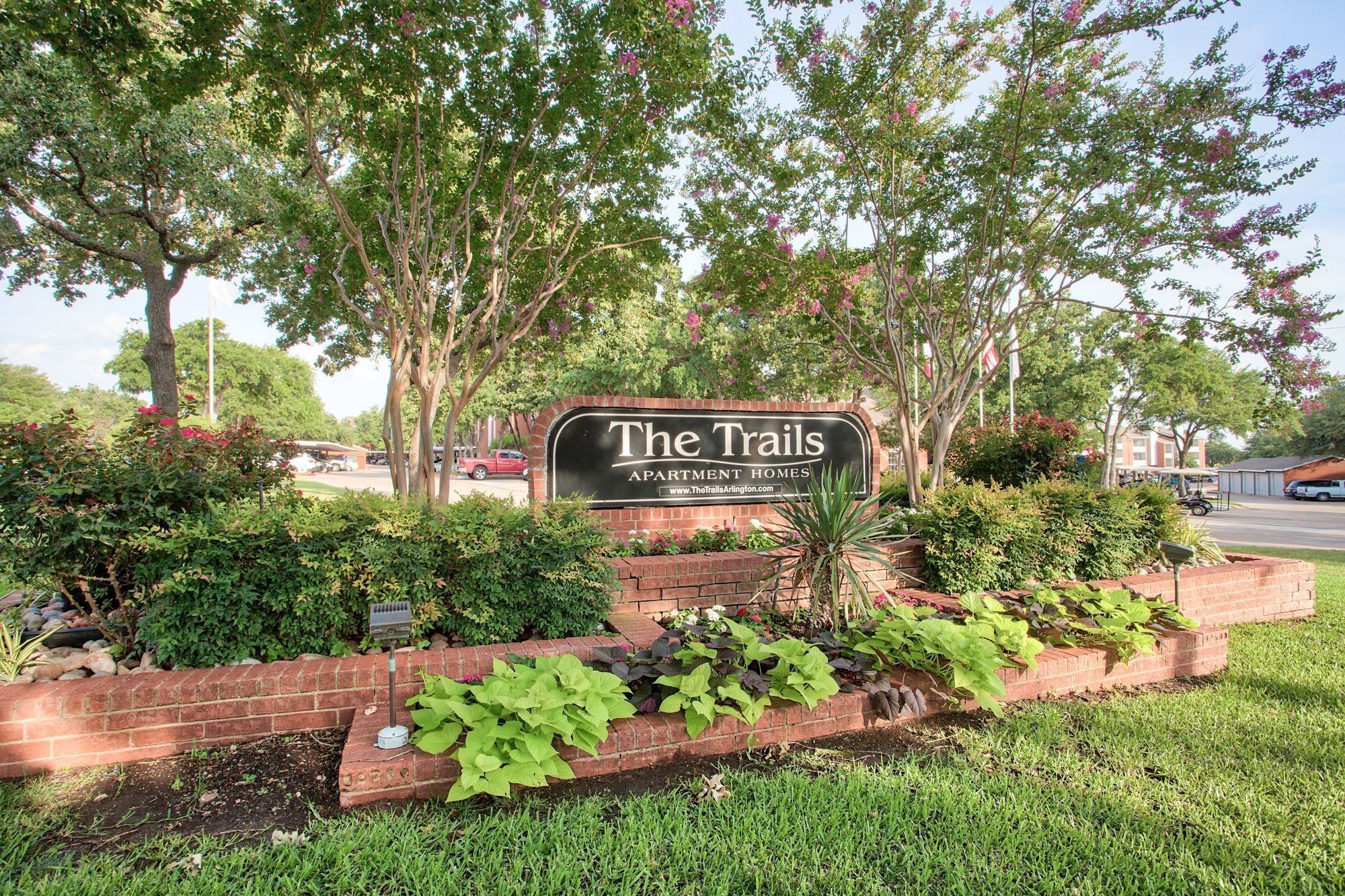 Exterior property sign at The Trails Apartments in Arlington, Texas