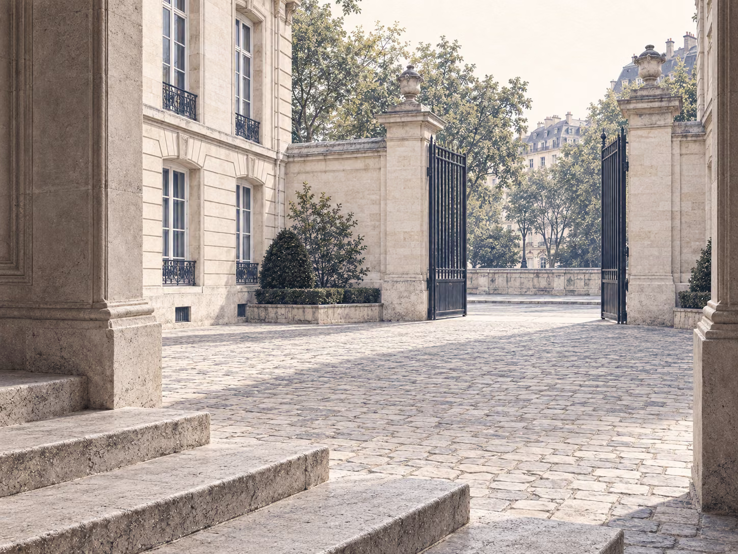 Marches de pierre et cour d’honneur vide, les grilles ouvertes sur la rue.