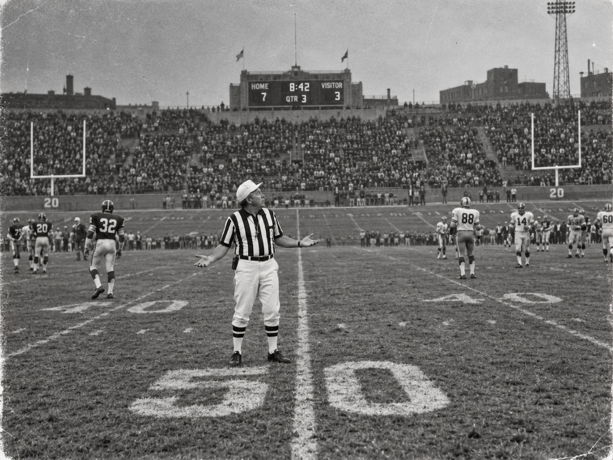 A referee shrugs at midfield, unsure which way the play went.