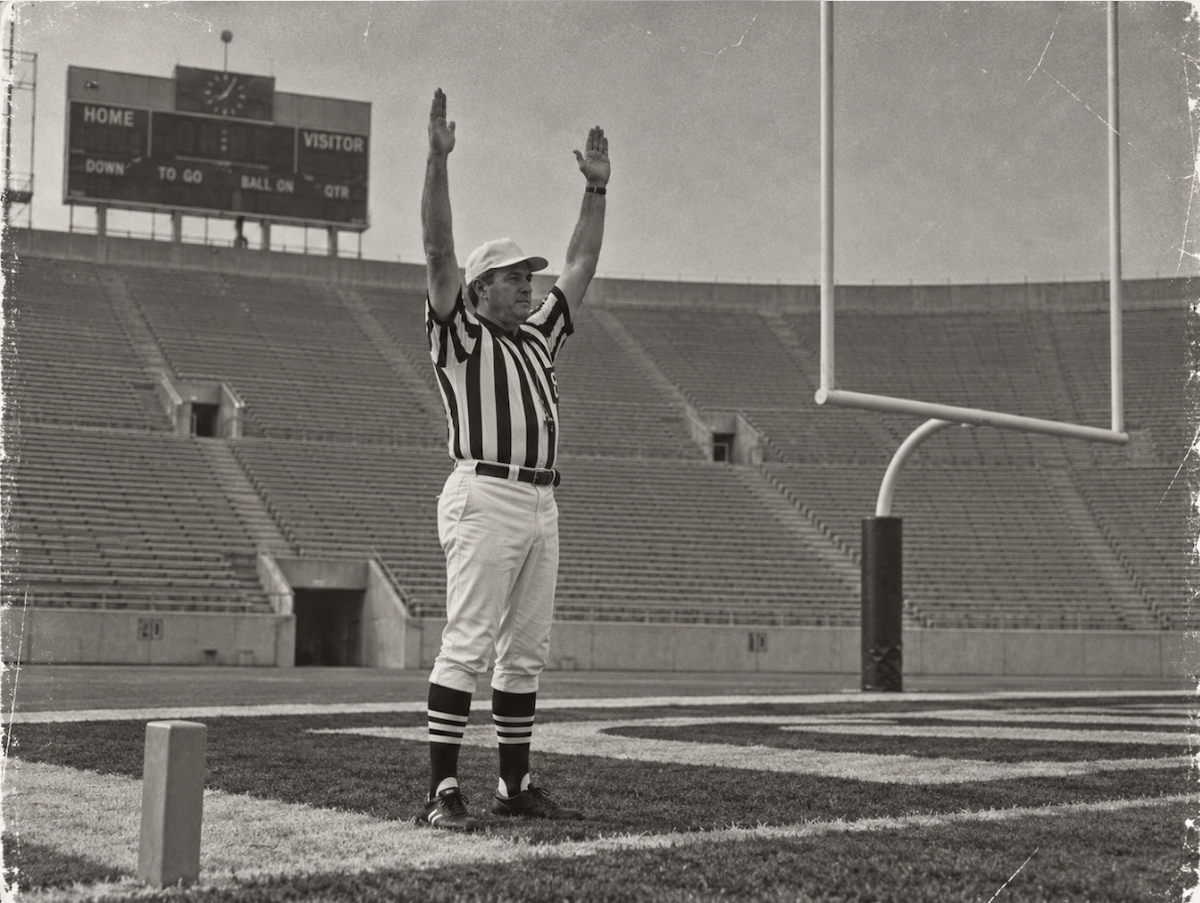 A referee signals touchdown to an empty stadium.