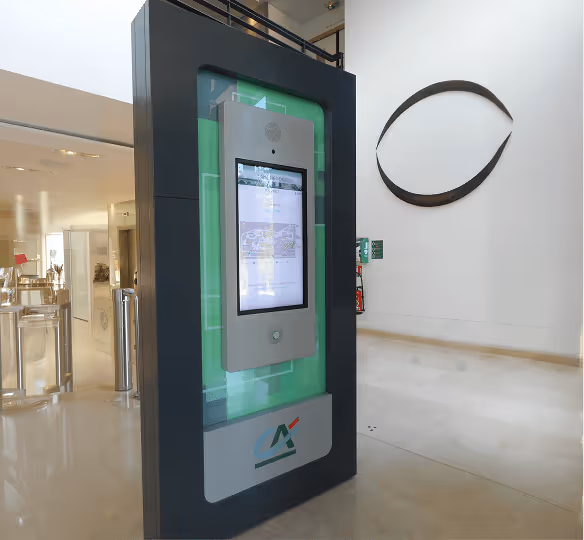 Kiosque numérique avec un écran tactile dans un hall moderne et lumineux.