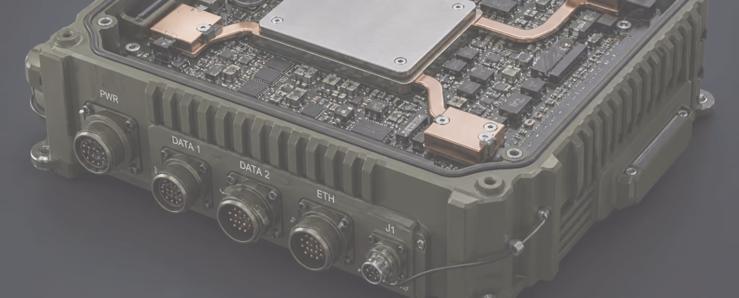 Gros plan d'un appareil électronique militaire avec plusieurs connecteurs et composants internes visibles.