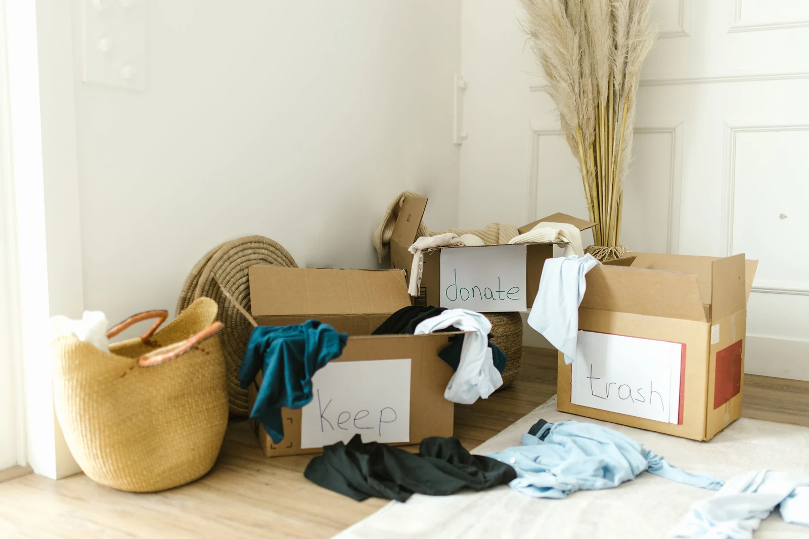 Boxes labeled keep, donate and trash used to sort belongings while decluttering before a move