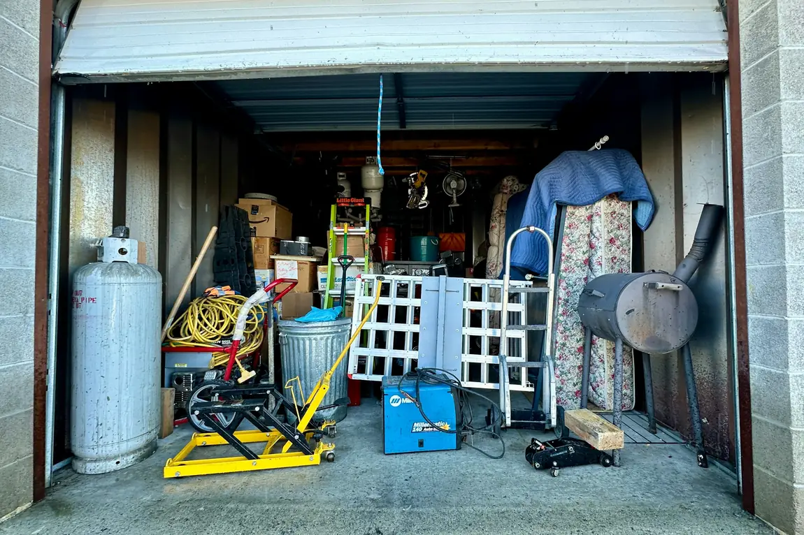 Backyard shed packed with stored household items, tools and yard equipment before a summer cleanout
