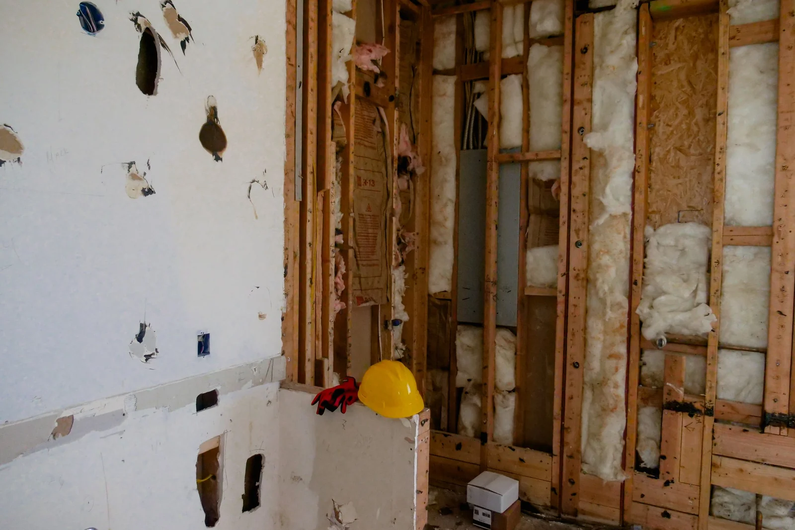 Interior renovation debris including torn-out drywall, insulation and framing lumber ready to load into a rental dumpster