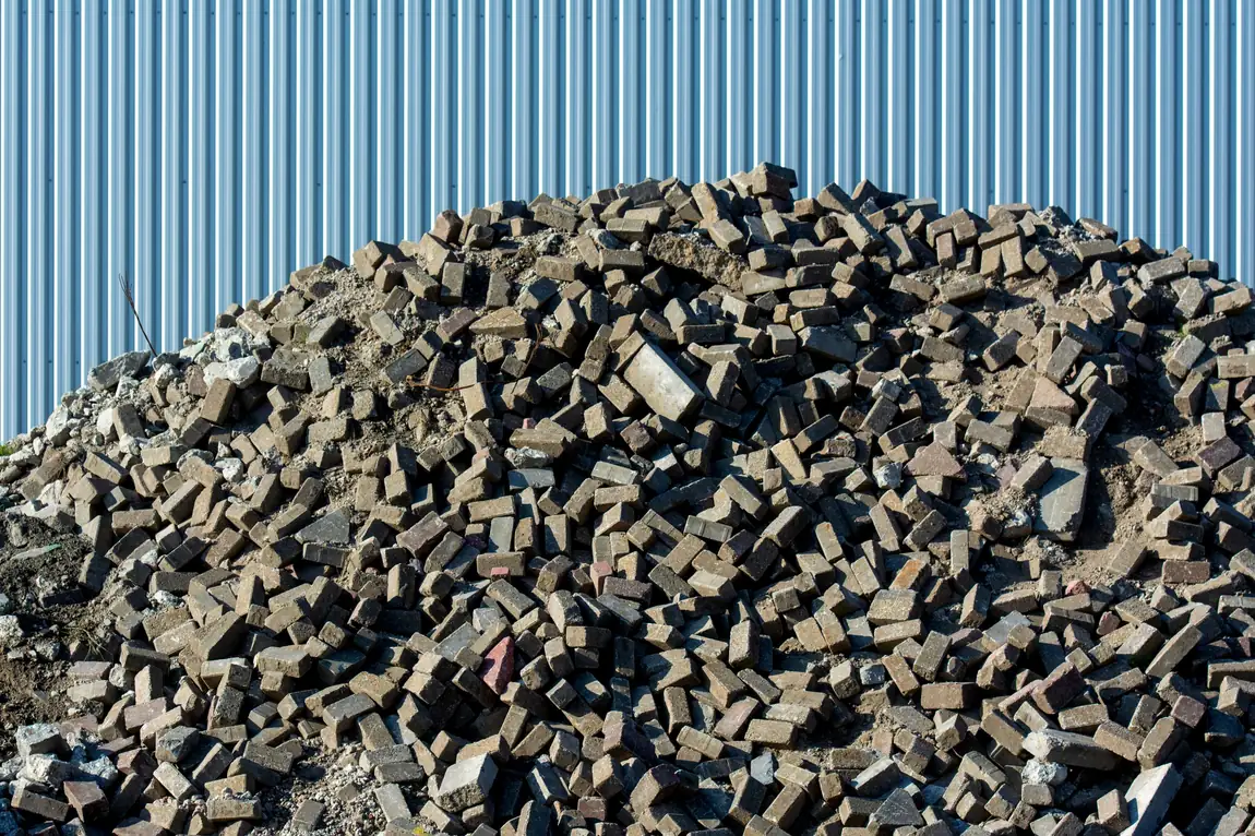 Pile of broken concrete and masonry debris at a demolition site awaiting heavy debris disposal
