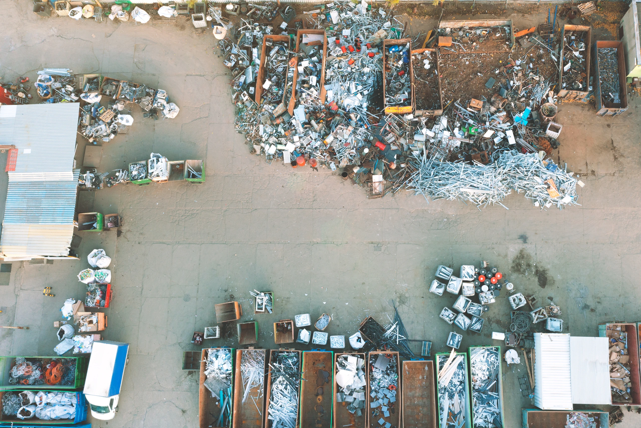 Aerial view of a scrap metal recycling yard with open top containers full of sorted metal and debris