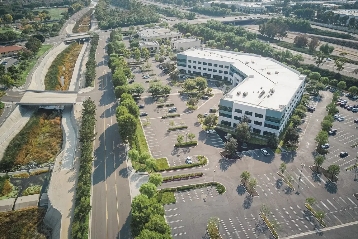 Aerial view of a suburban office business park with large parking lots and multiple commercial tenants