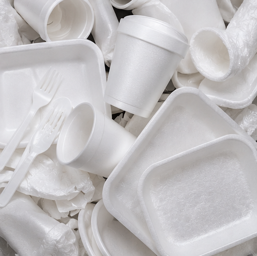 A collection of white disposable foam food containers, cups, and plastic cutlery.